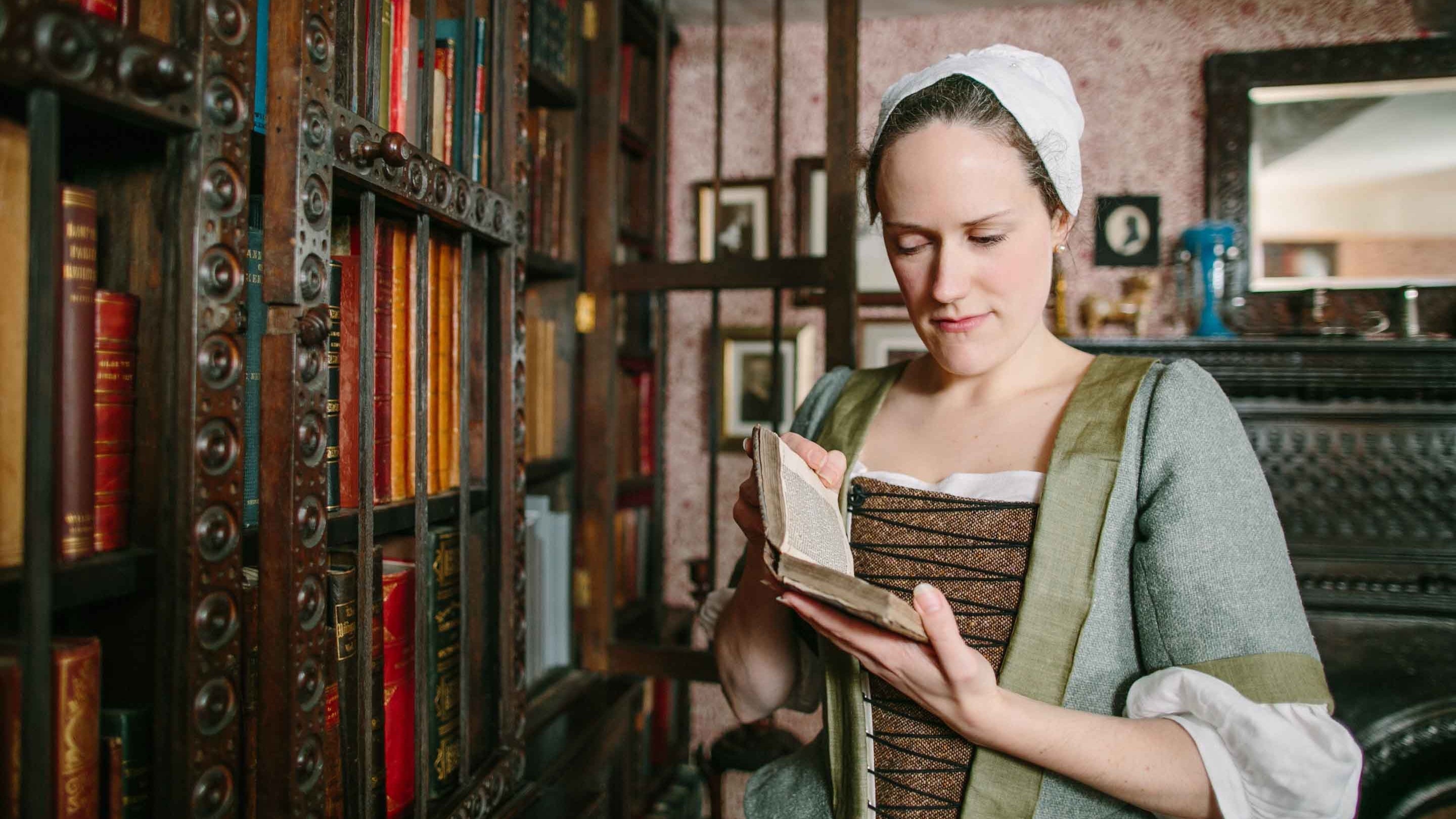 A costumed woman in the library at Townend in Troutbeck, Cumbria