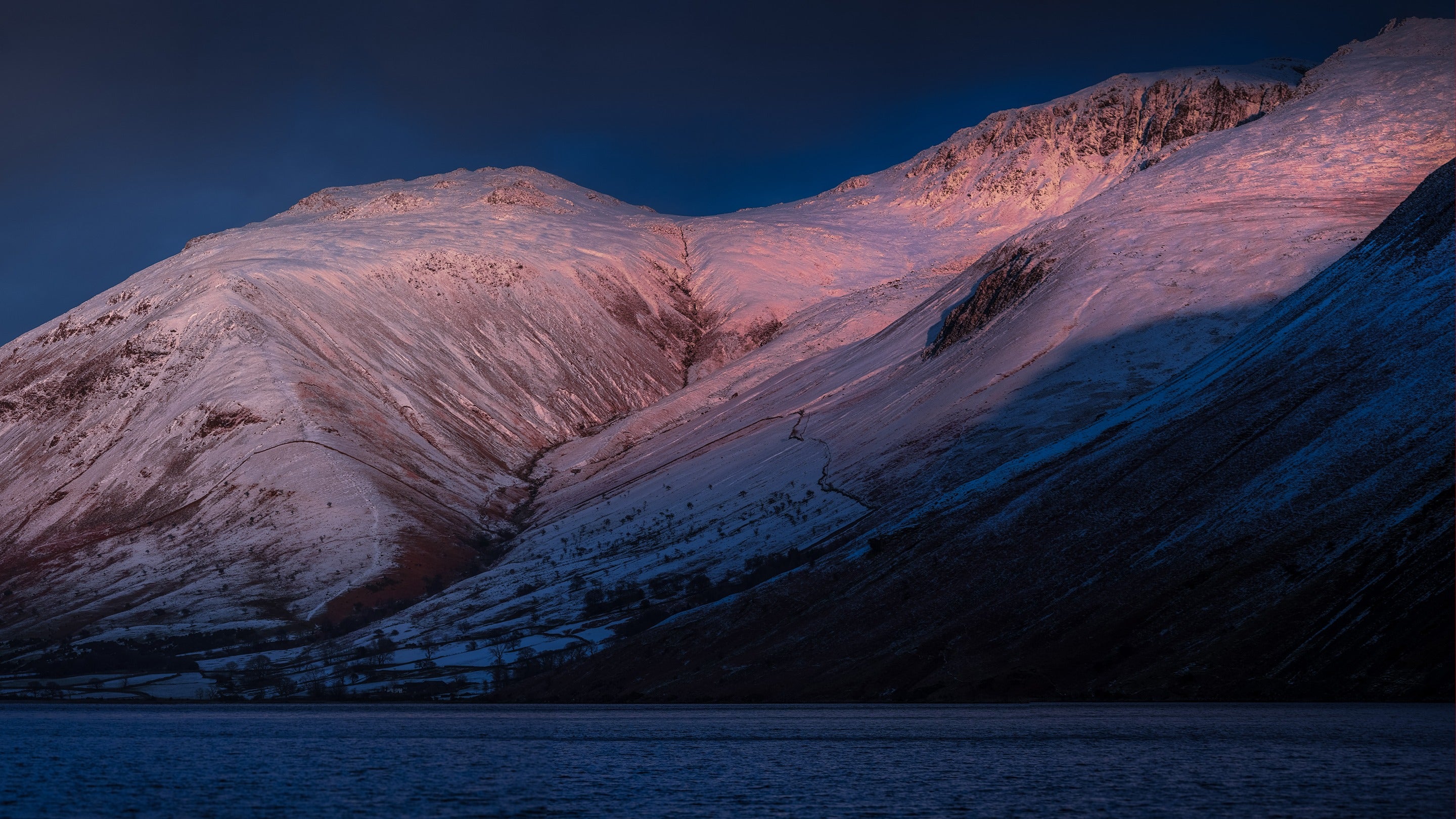Snow covered mountains in the pink winter light at sunset in Wasdale, Cumbria