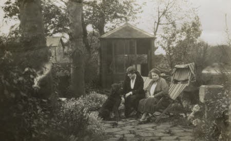 An old black and white photograph of Gabrielle Ellis sitting on the terrace of Wordsworth House with her mother and dog.