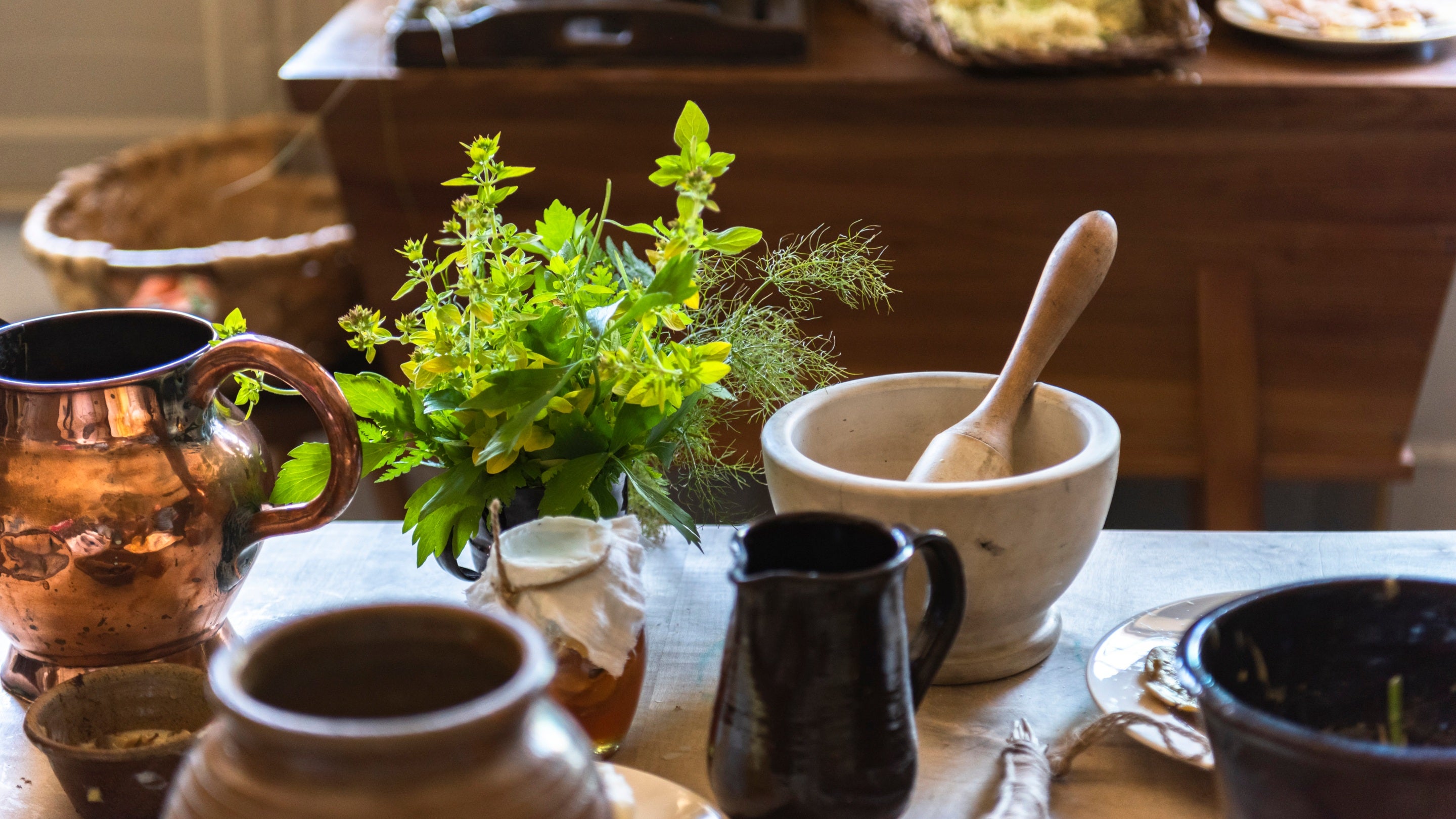 Detail of the table in the Kitchen with freshly picked herbs and pestle and mortar at Wordsworth House, Cumbria