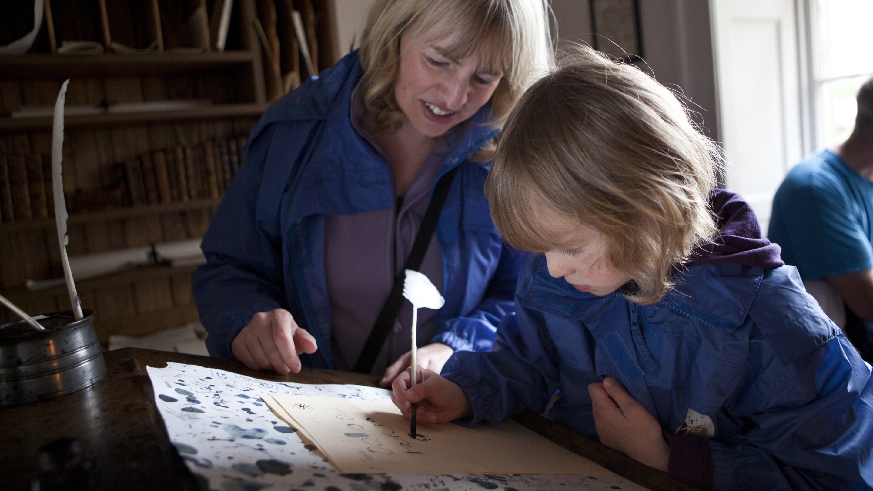 Visitors try out writing with a quill in the office at Wordsworth House, Cockermouth