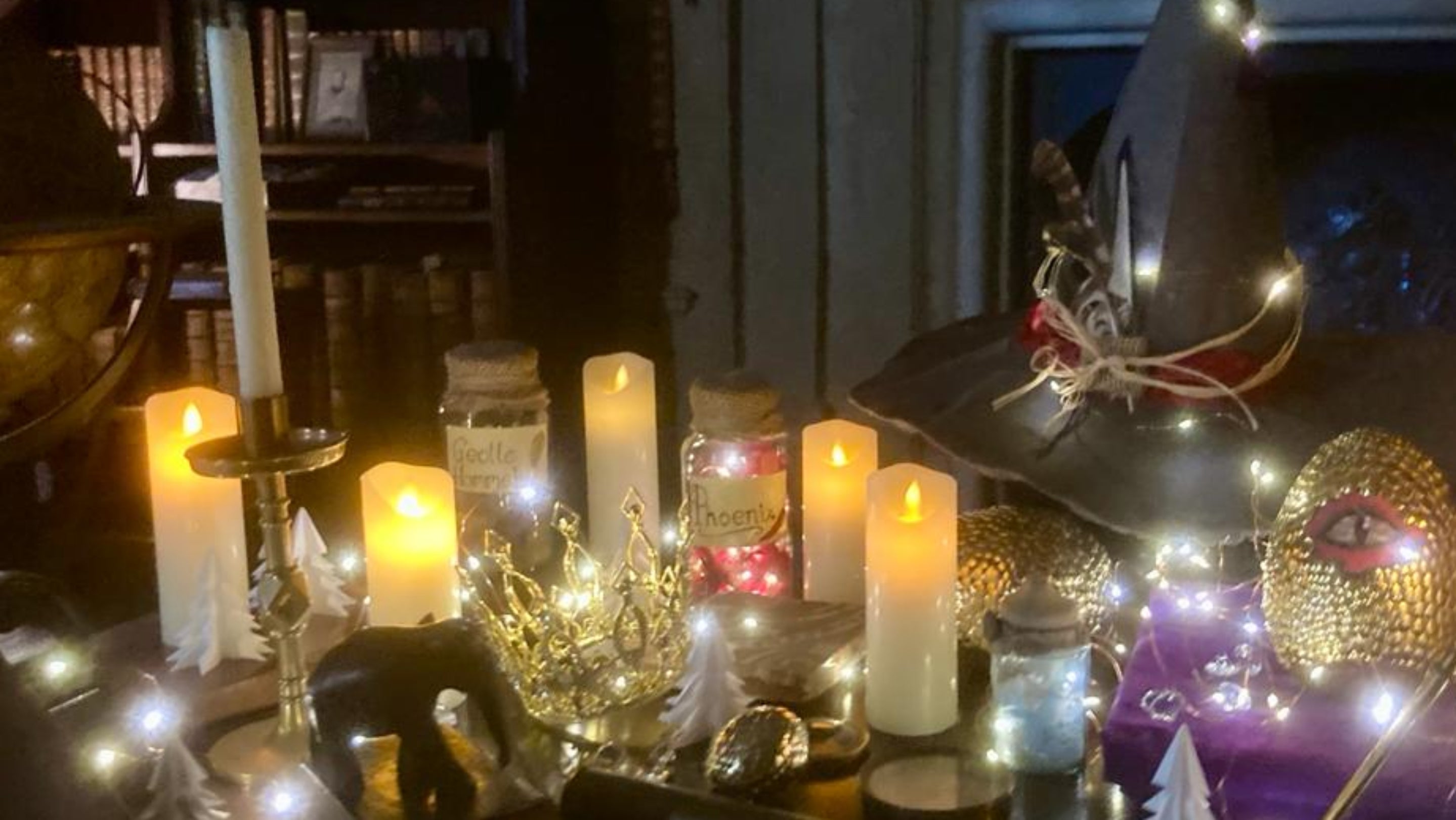 Christmas decorations including candles, potions, witches hat and Christmas lights on table in room at Canons Ashby Northamptonshire