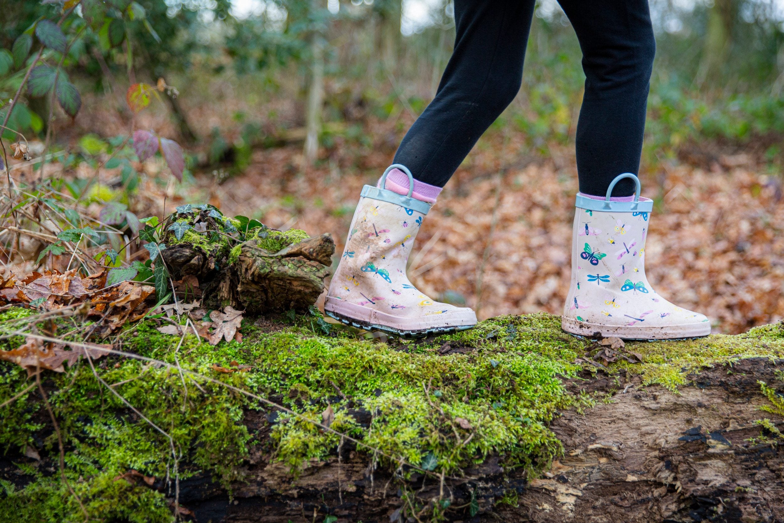 Wellied feet walking along a log