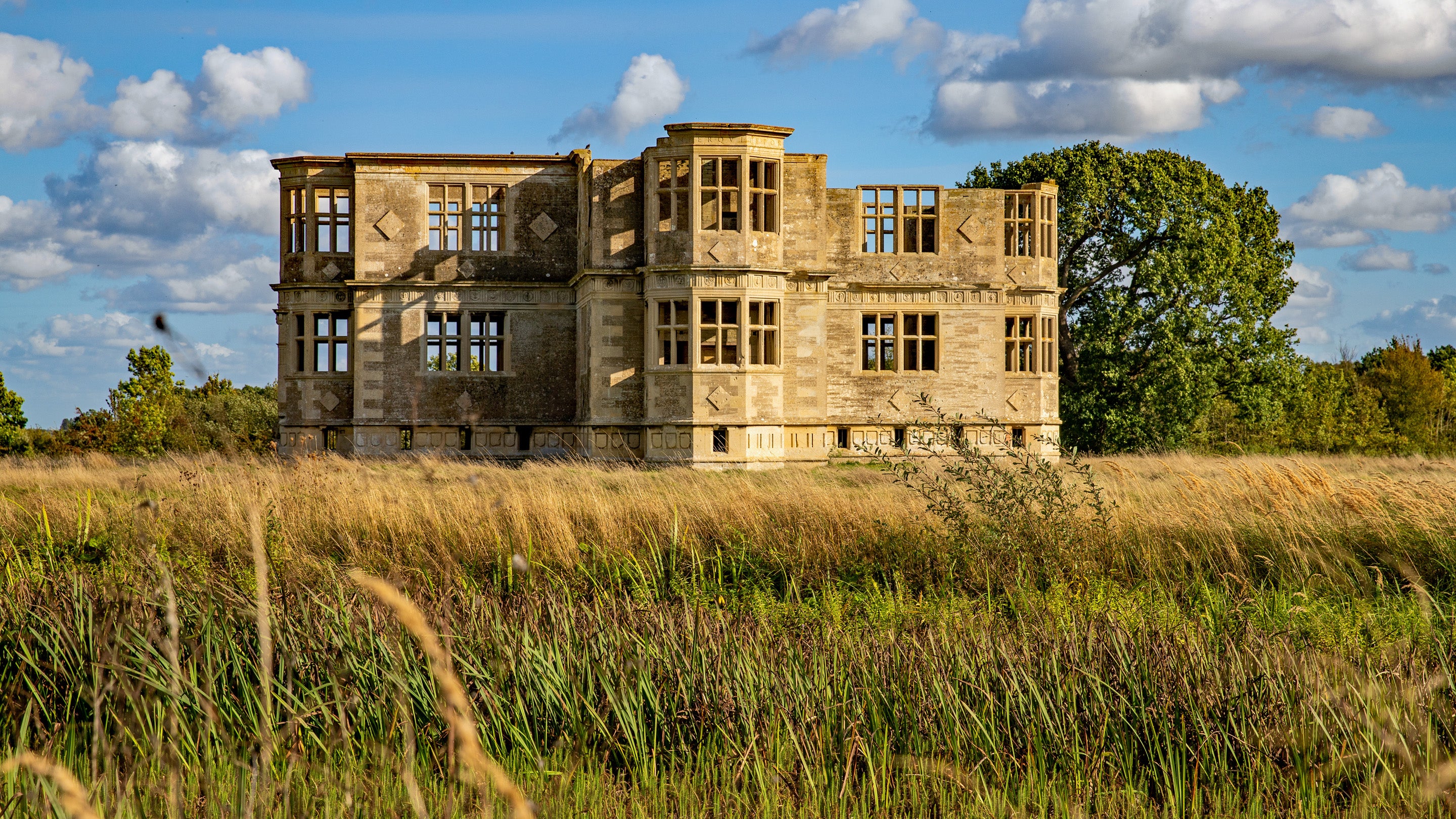 The Garden Lodge surrounded by long grass in the summer.