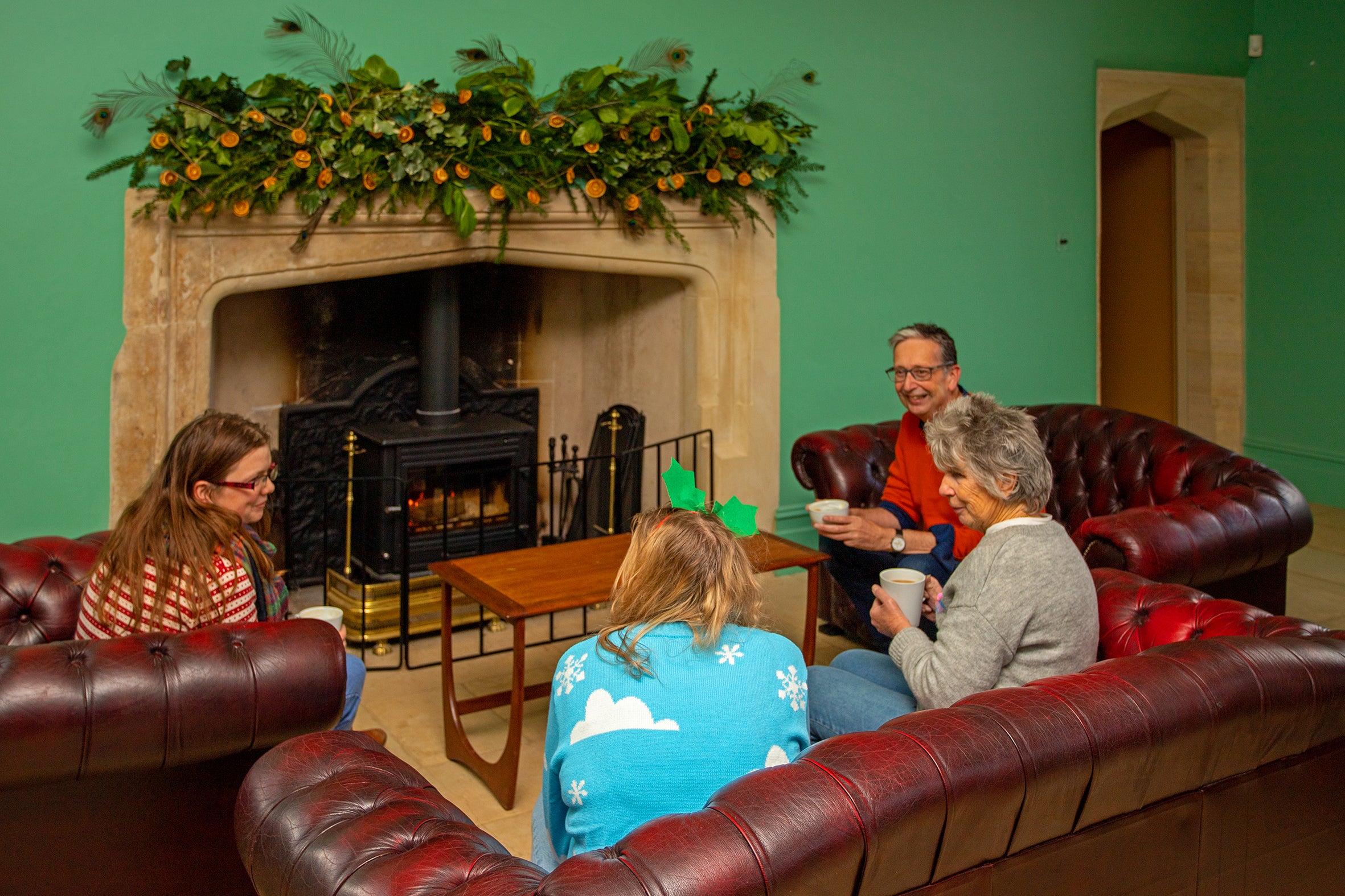 Visitors to Lyveden enjoy festive treats by the fire in the decorated cafe.