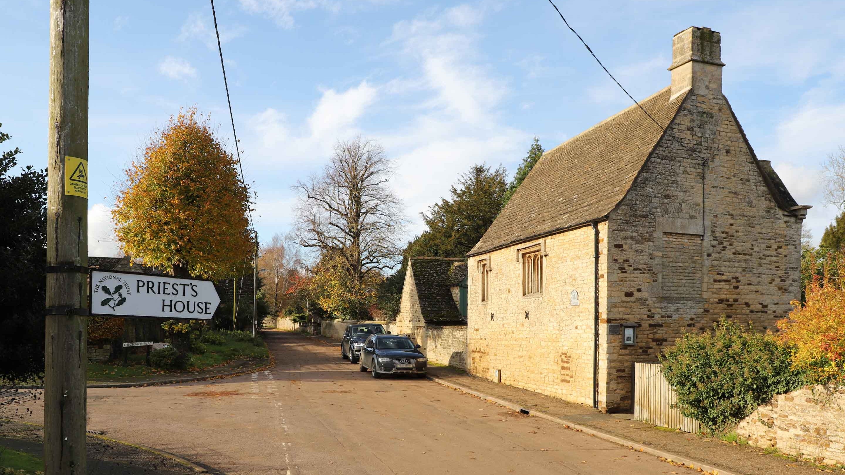 Signpost pointing the way to the Priest's House, a stone building with a pitched roof, Easton On The Hill, Northamptonshire