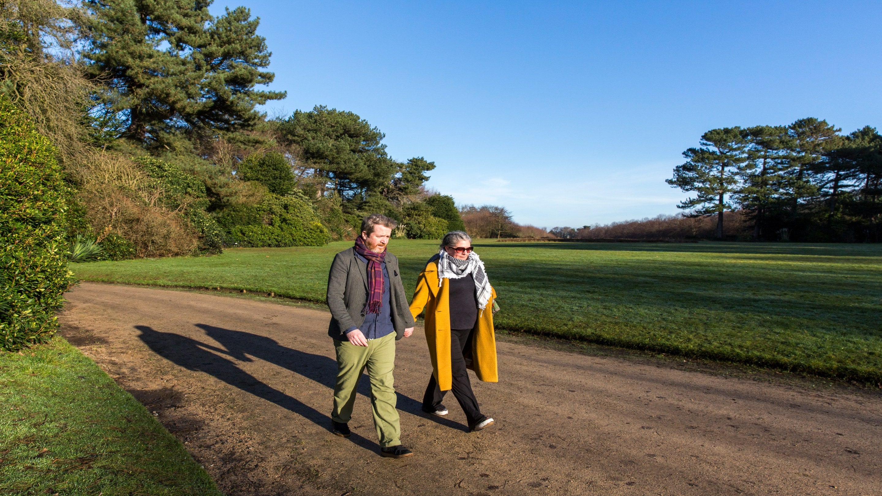 A couple walking through the grounds of Speke Hall in autumn