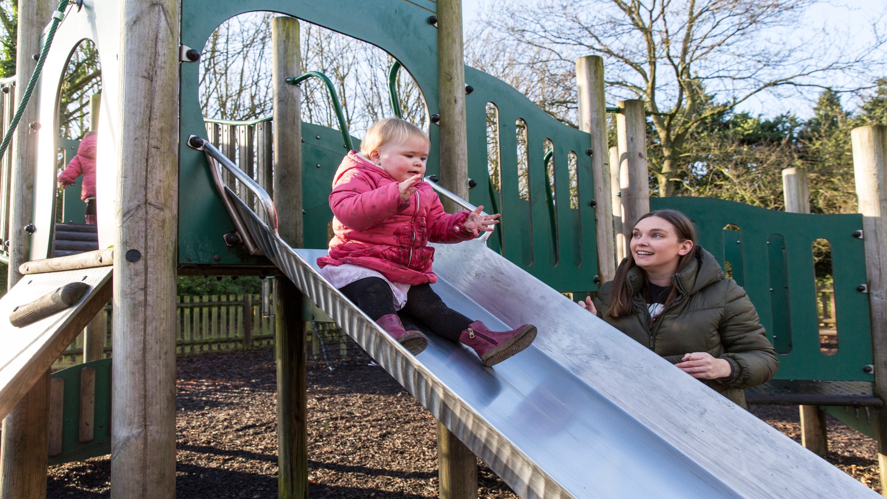 A family playing on the slide in the play area at Speke Hall, Liverpool