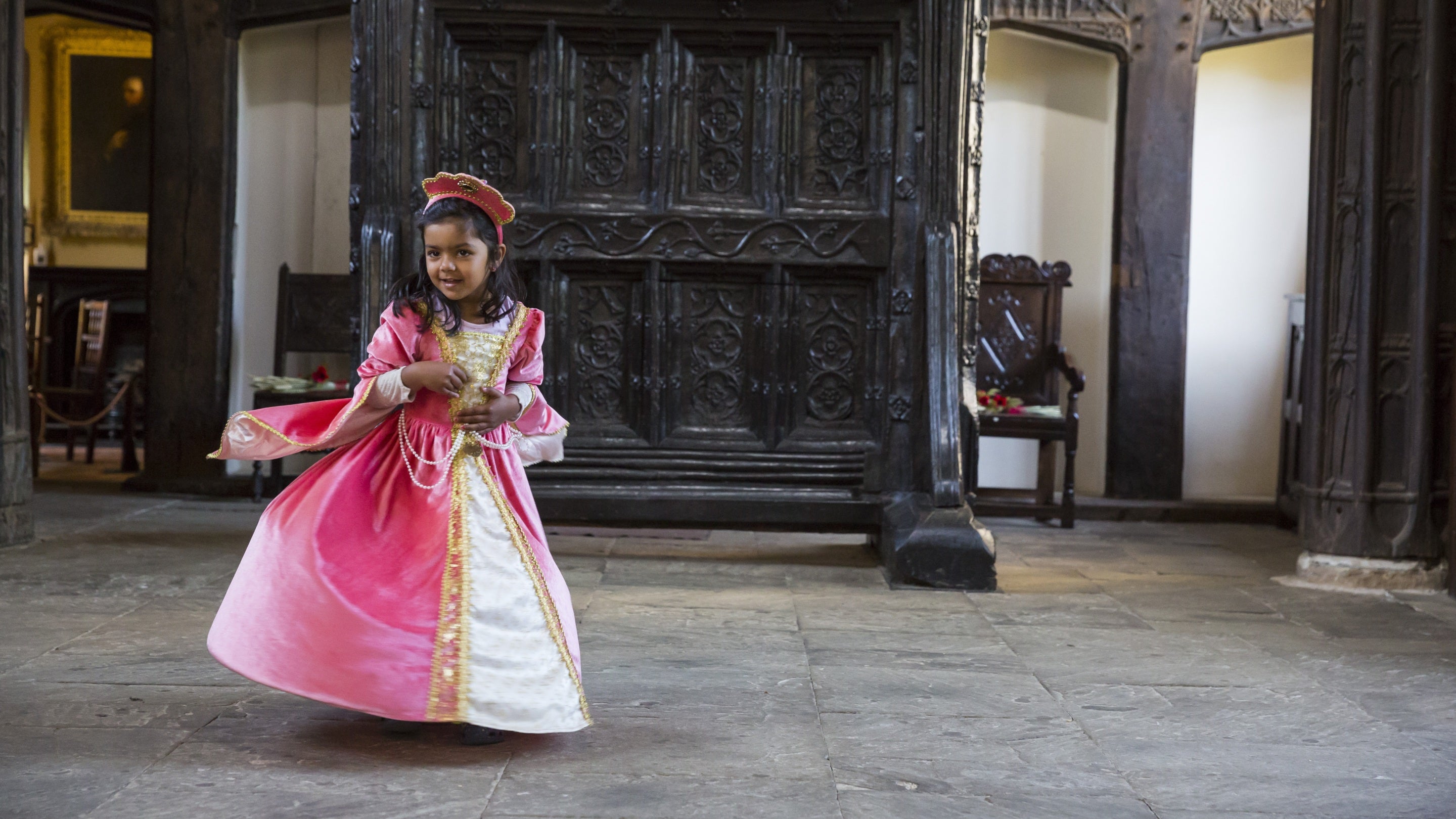 Girl dressed up in a pink Tudor costume at Rufford Old Hall, Lancashire
