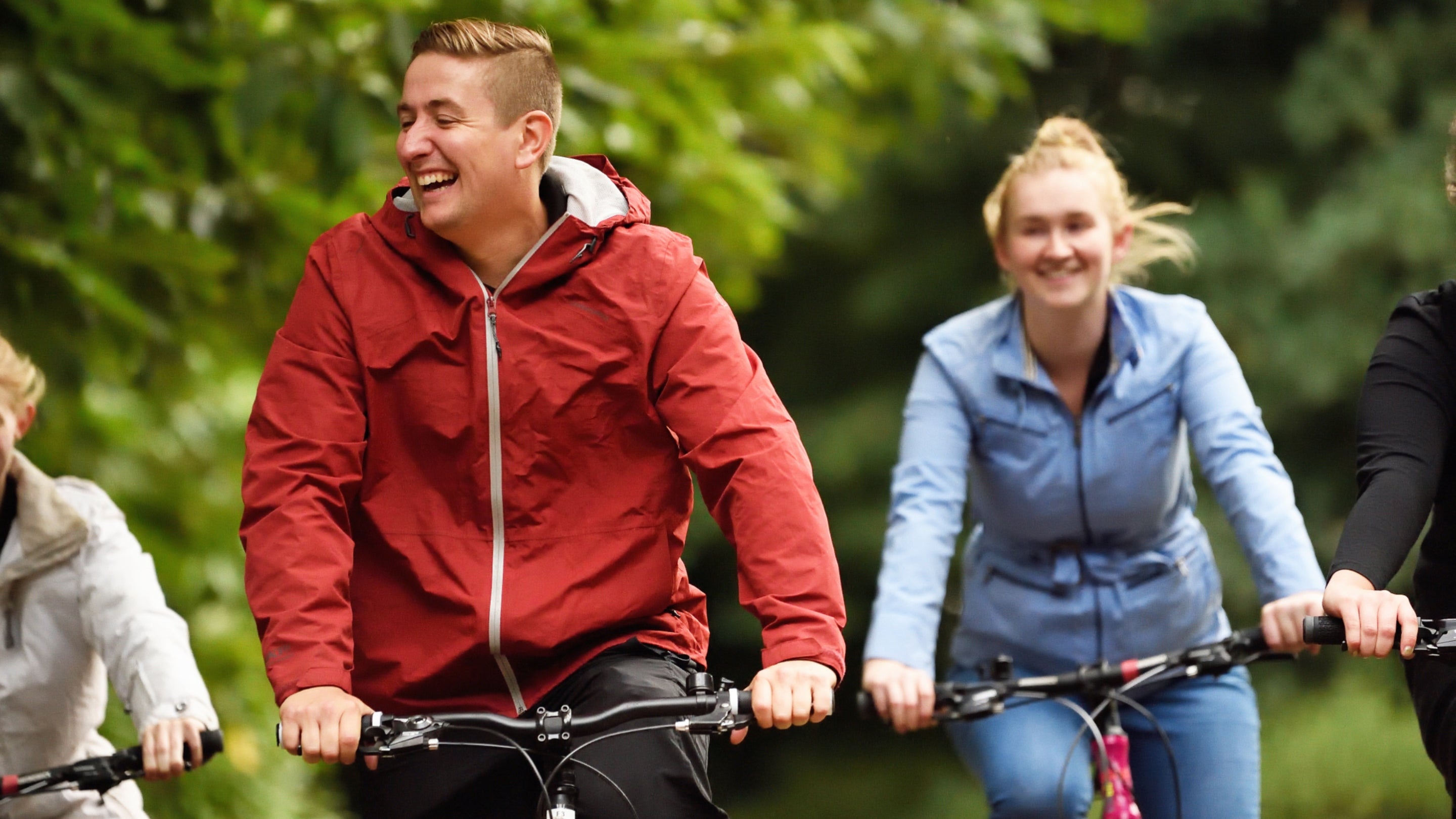 People smiling while they ride their bikes at Clumber Park