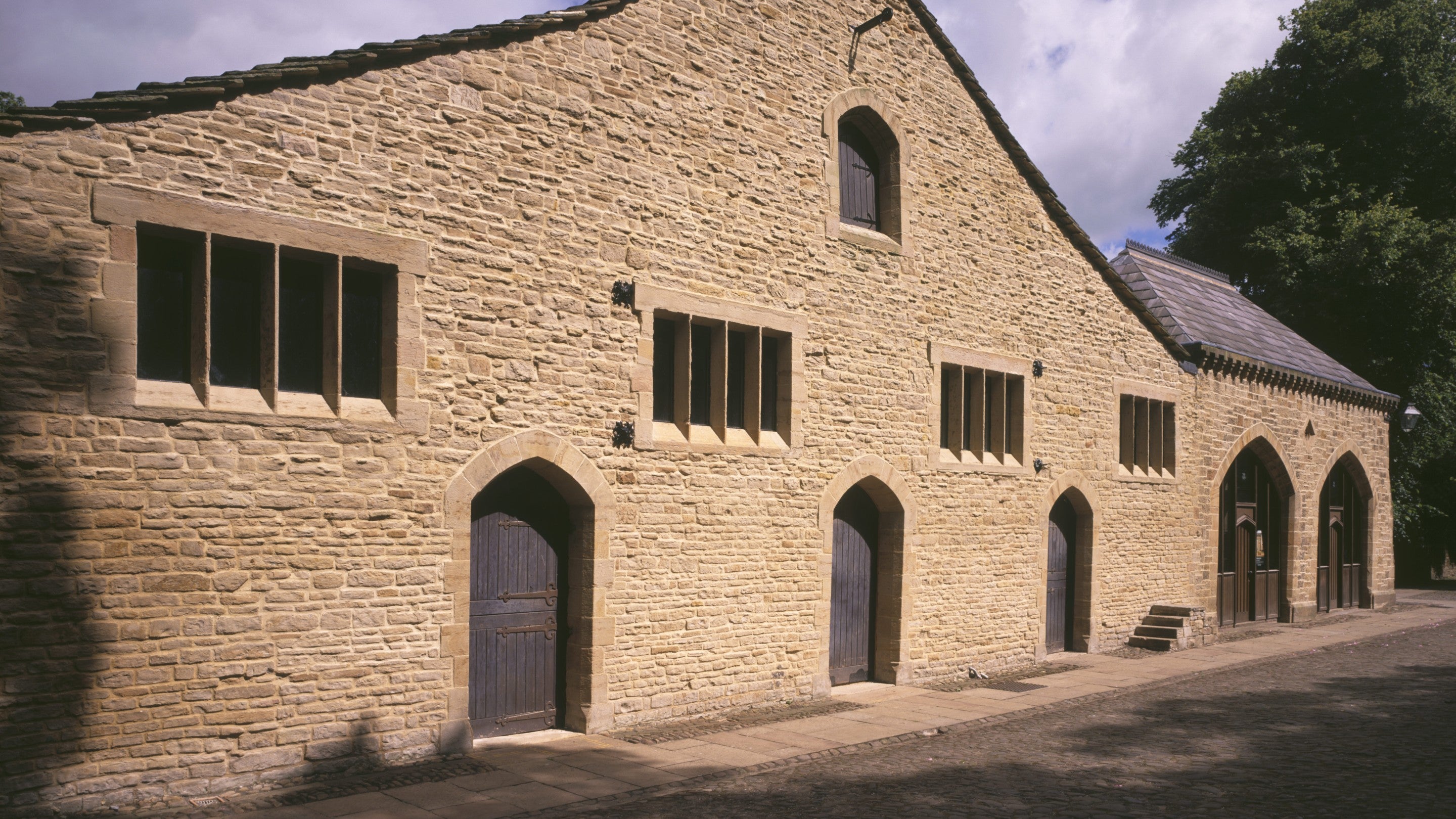 An image of the yellow brick Great Barn at Gawthorpe Hall.