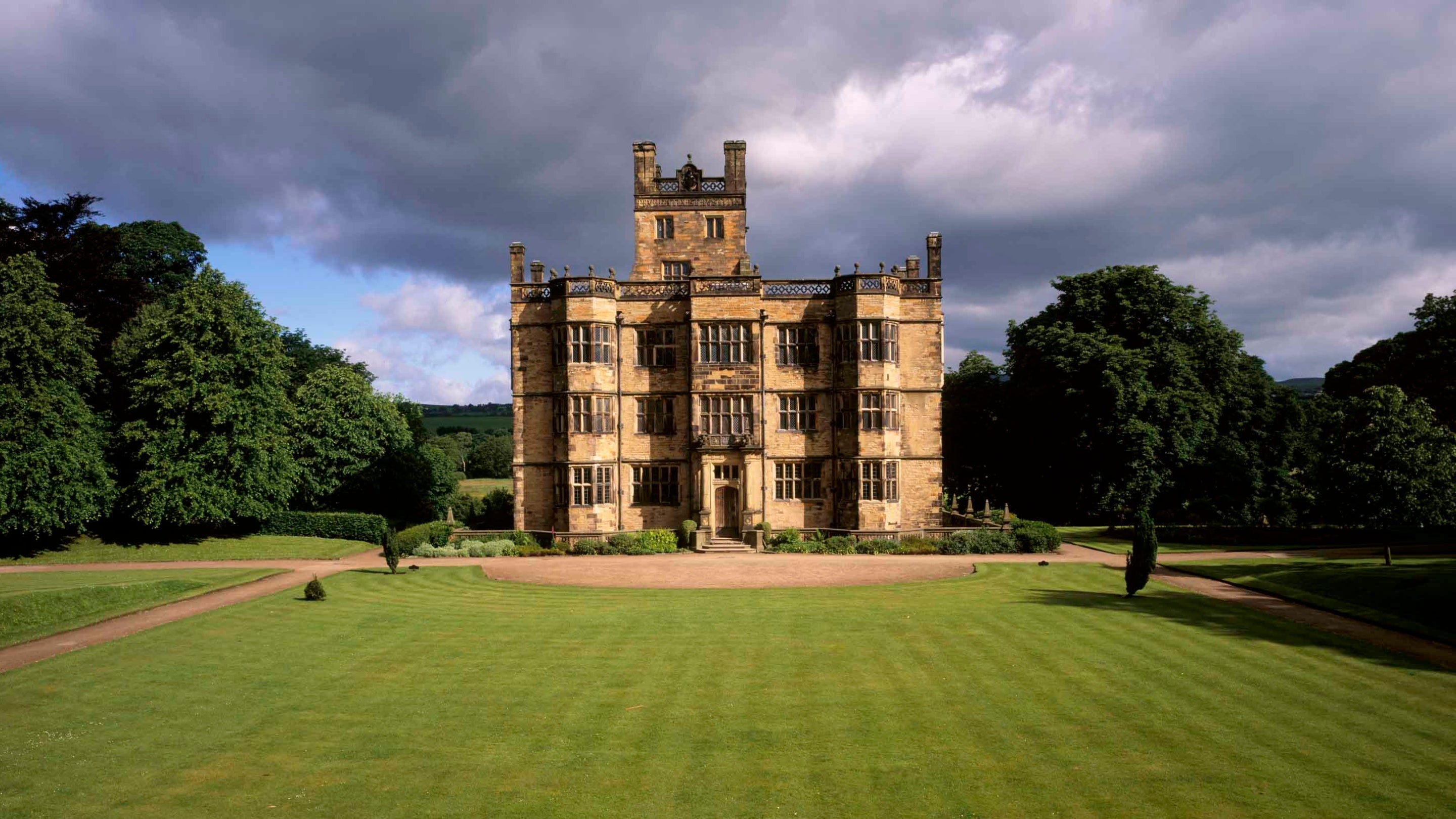 A view of the South Front of Gawthorpe Hall set in it's grounds on a stormy day