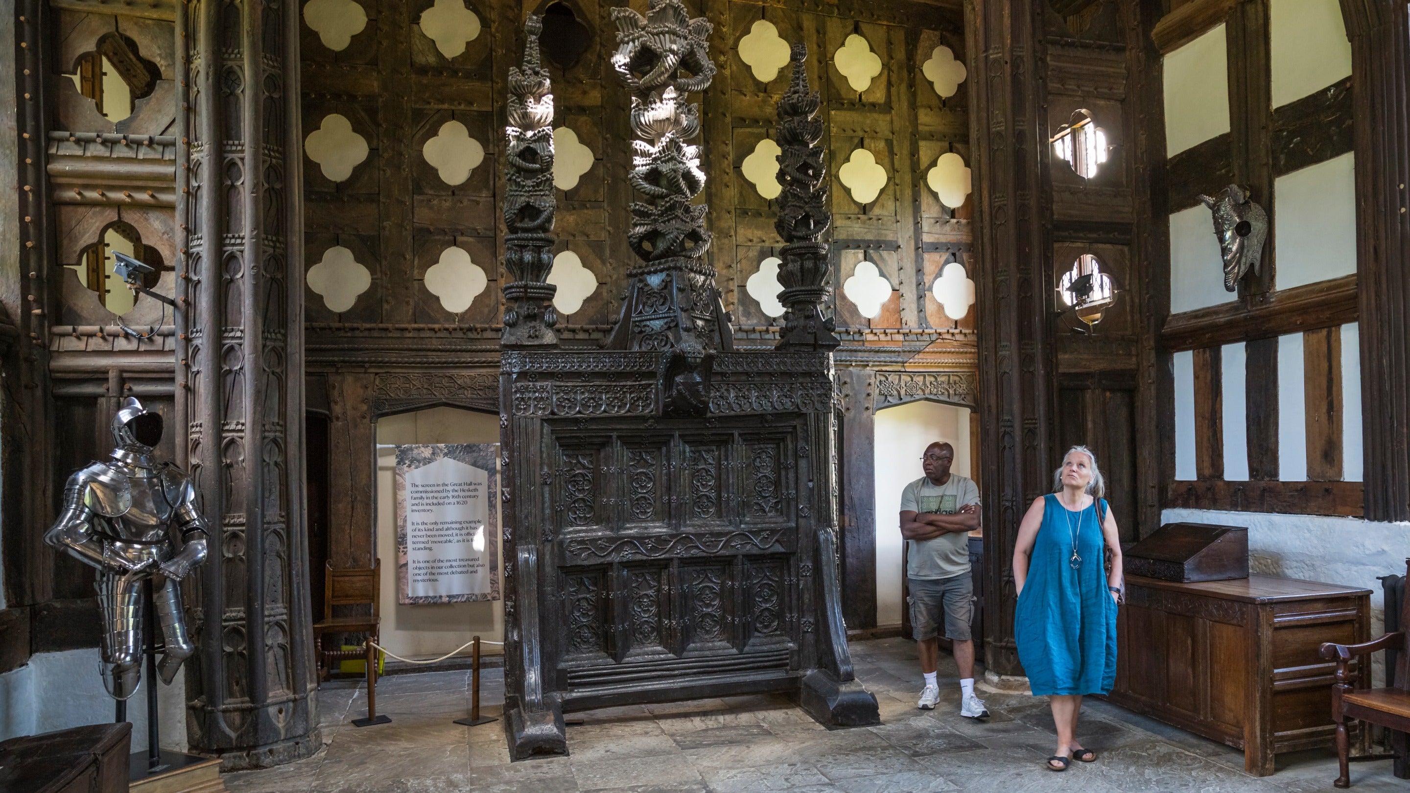 Two visitors in the Great Hall at Rufford Old Hall, Lancashire. They are looking up at the ceiling.