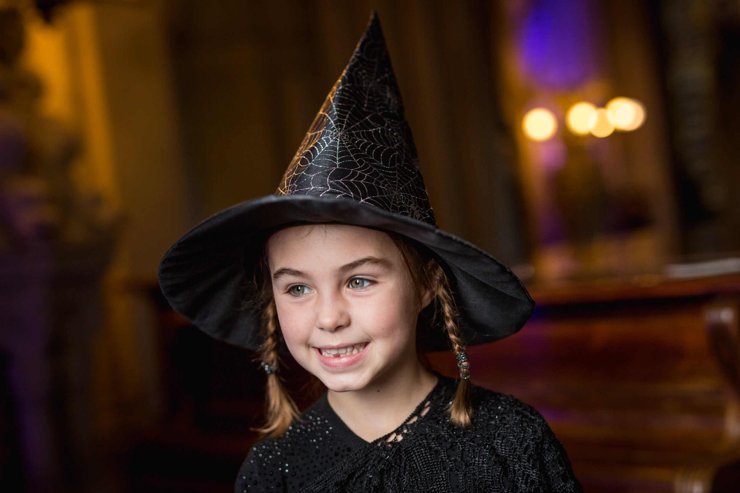 A young girl in a witch's hat, enjoying a National Trust halloween event