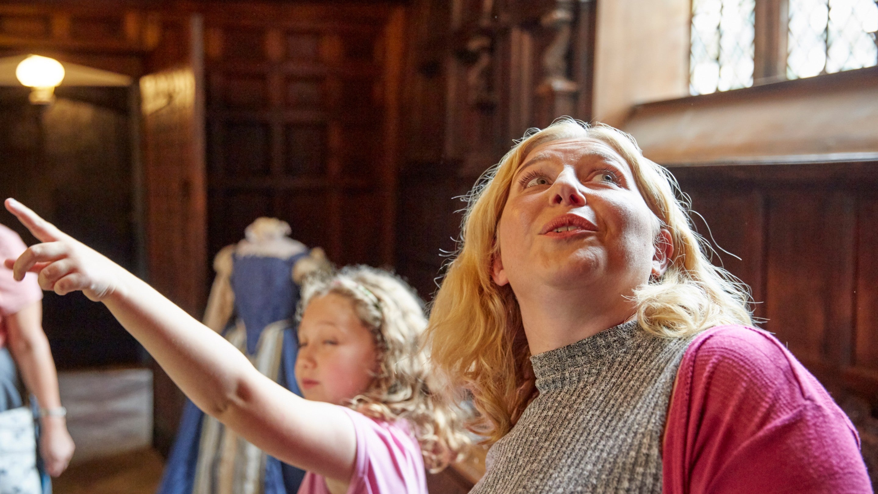 A woman and child looking wondrously inside a room at Speke Hall