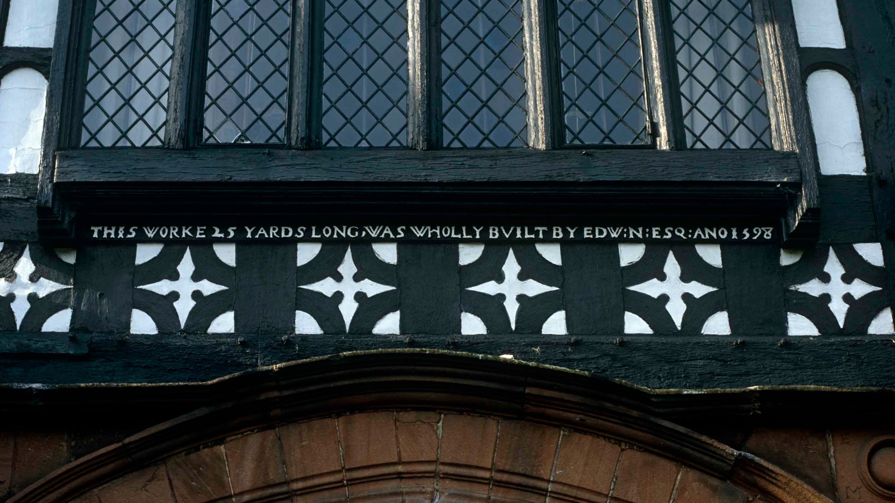 A detailed close up of the entrance portico at the North Front of Speke Hall. The inscription over the gatehouse records that Edward Norris built the north range in 1598.