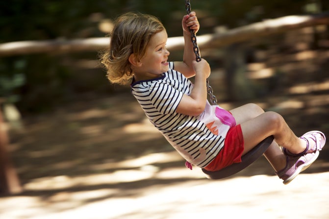 Child using a rope swing in the grounds at Speke Hall, Garden and Estate, Merseyside.  1088277