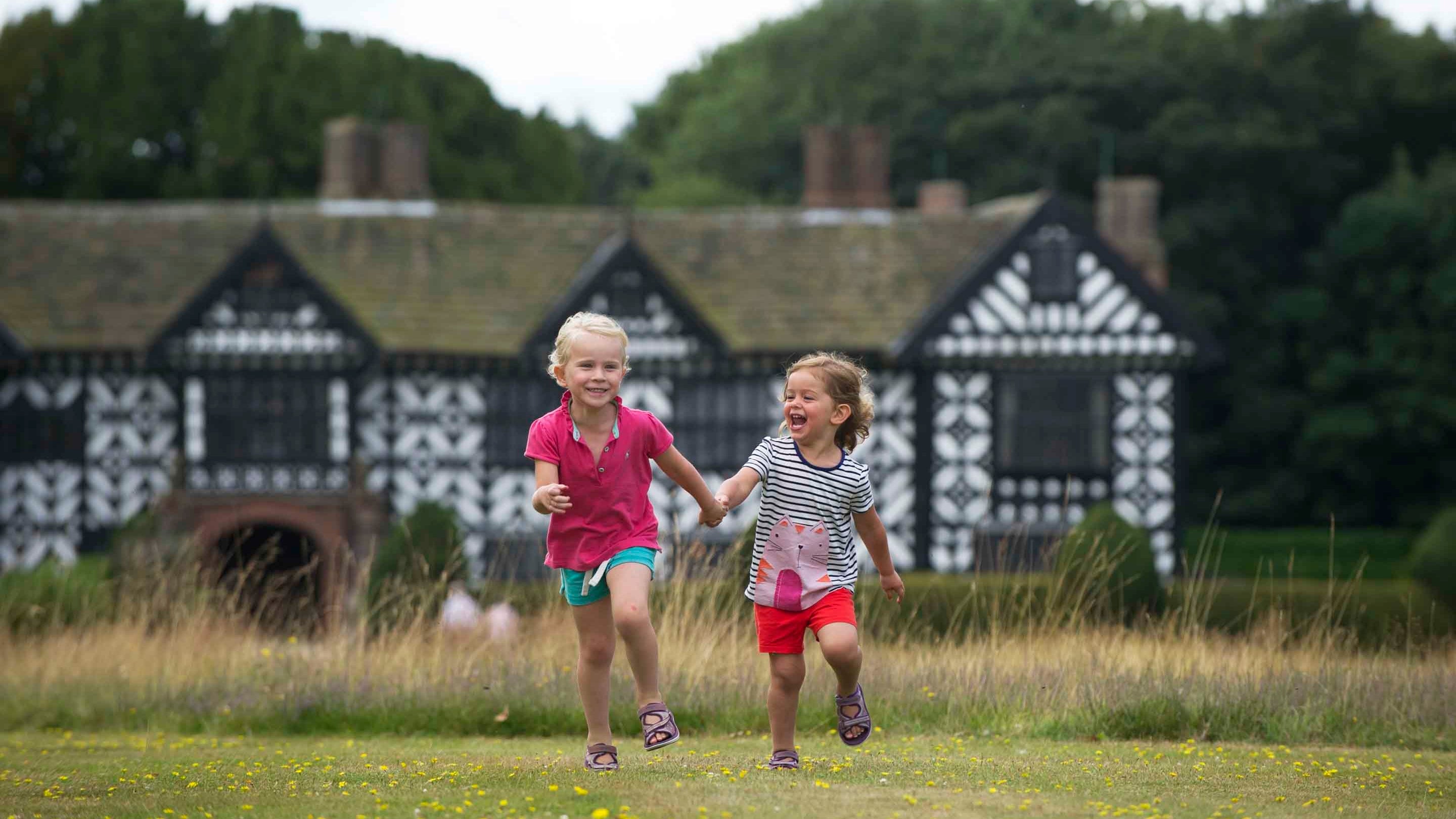 Children playing in the garden at Speke Hall, Garden and Estate, Merseyside. Speke Hall is a Tudor manor house with Victorian interiors, including original William Morris wallpaper.