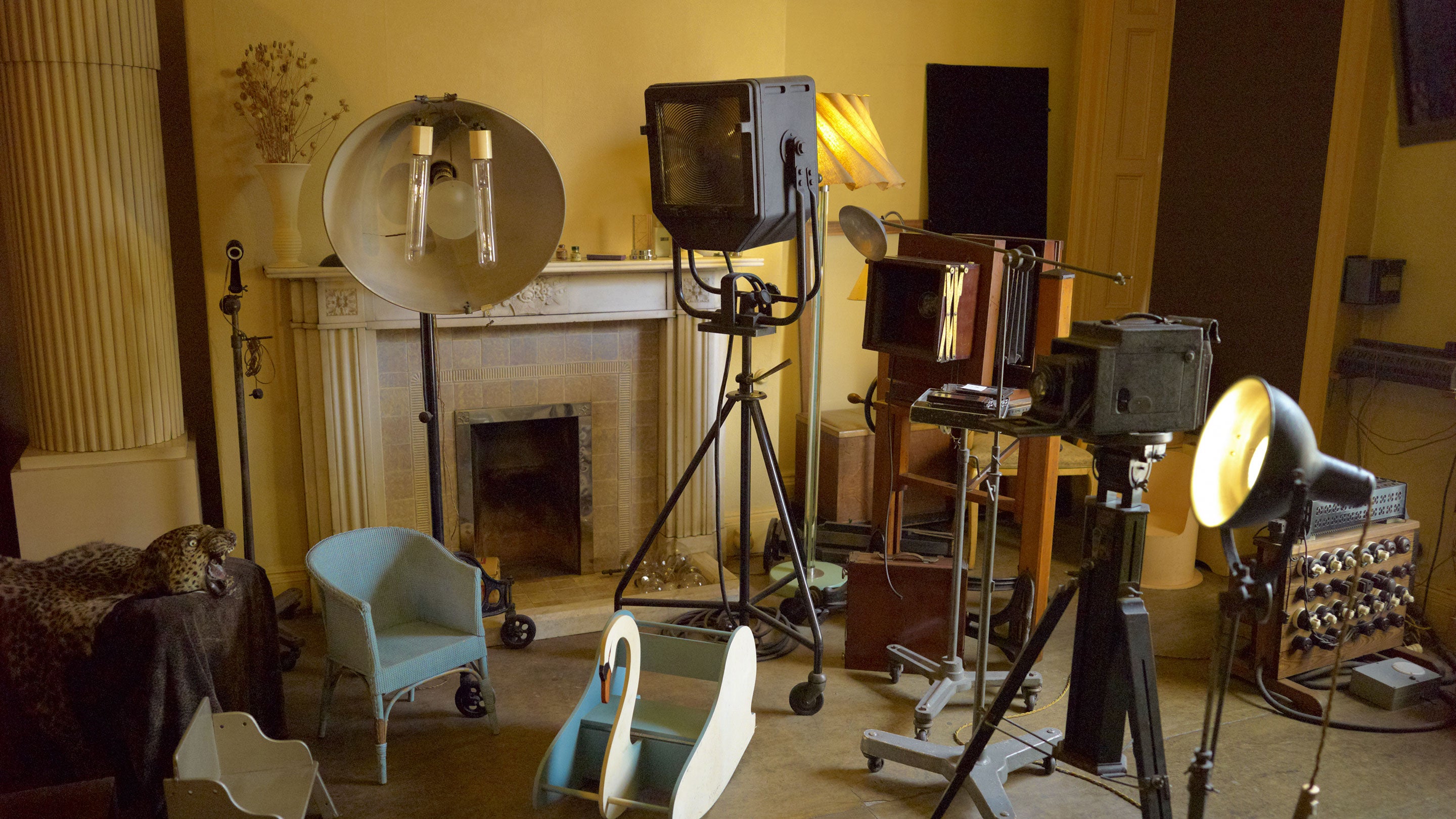Interior shot of the photography studio with a collection of studio lights and cameras of differing ages.