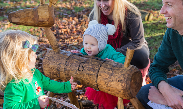 A family gathered around a wooden reindeer