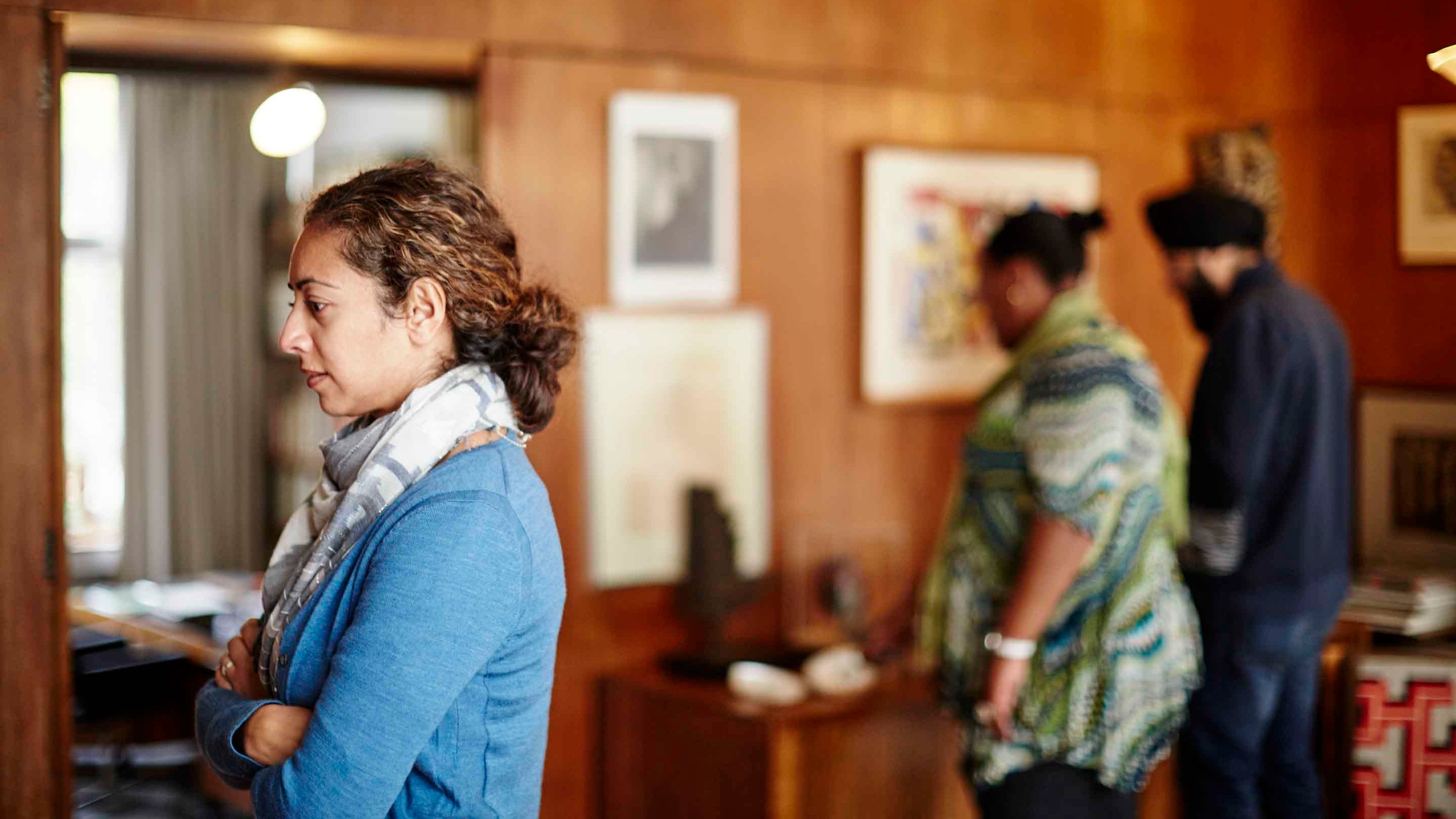 Three visitors inside 2 Willow Road looking at items around a room