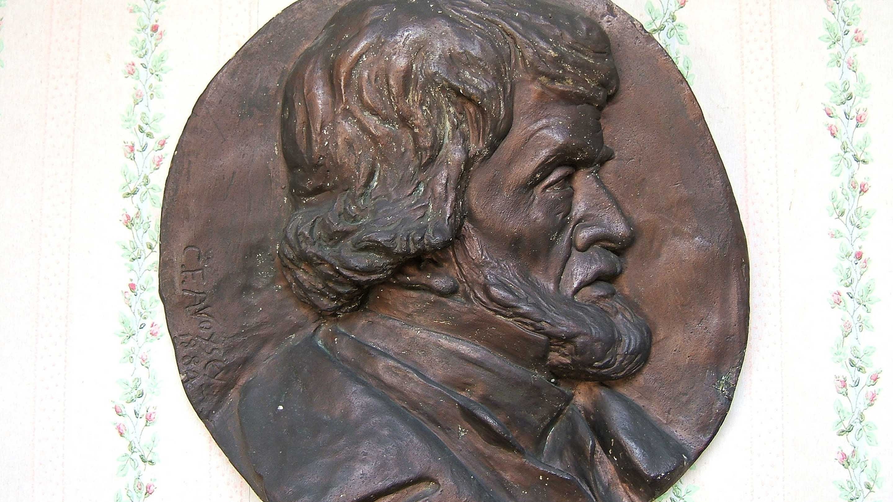 An image of a metal-effect plaque of Thomas Carlyle's head in profile. It is a copy of medallion affixed to the front of the house.