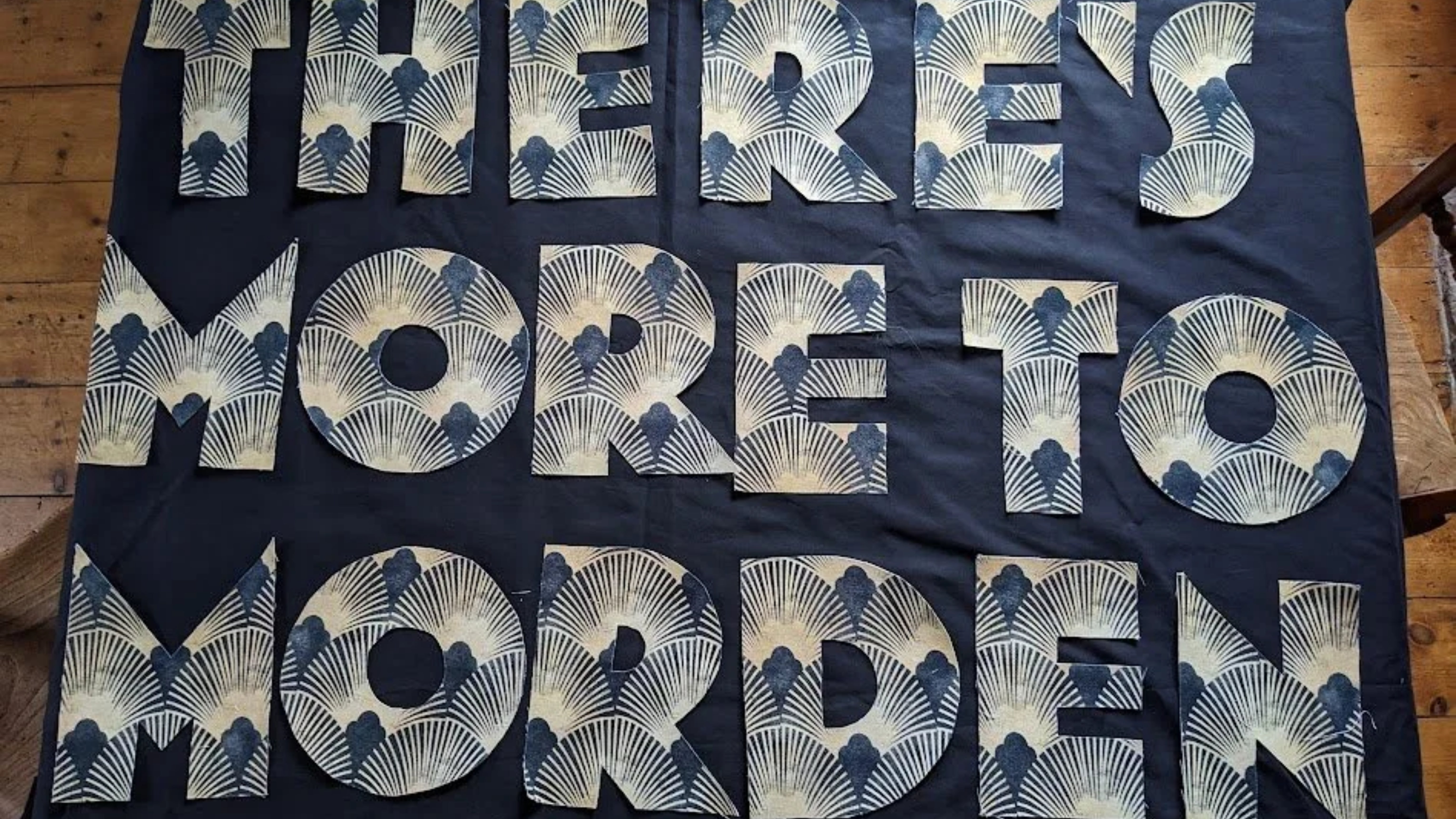 A blue quilt with the words 'Made in Morden' stitched on the front.