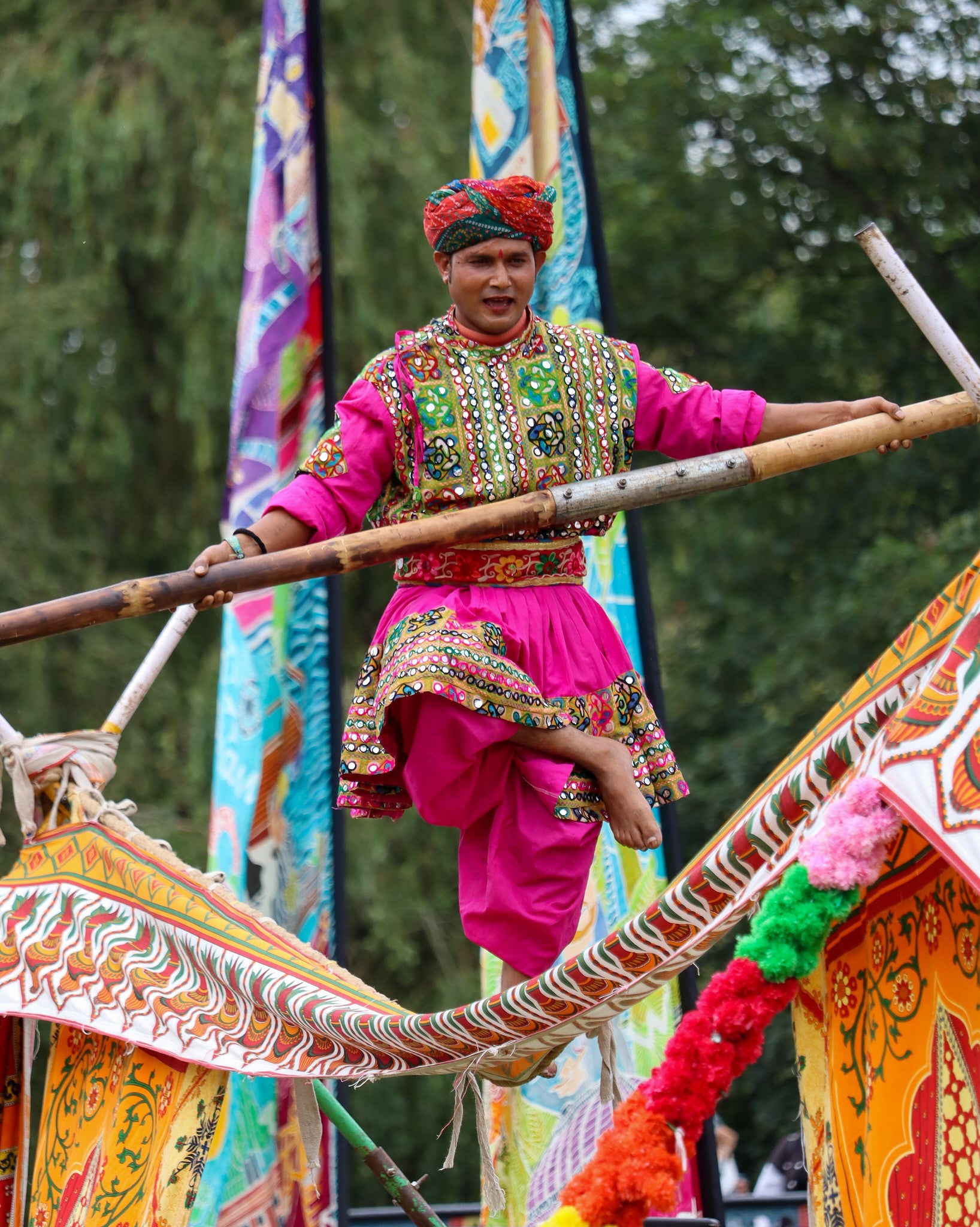 Tightrope walker in gardens at Rainham Hall, brightly dressed costume