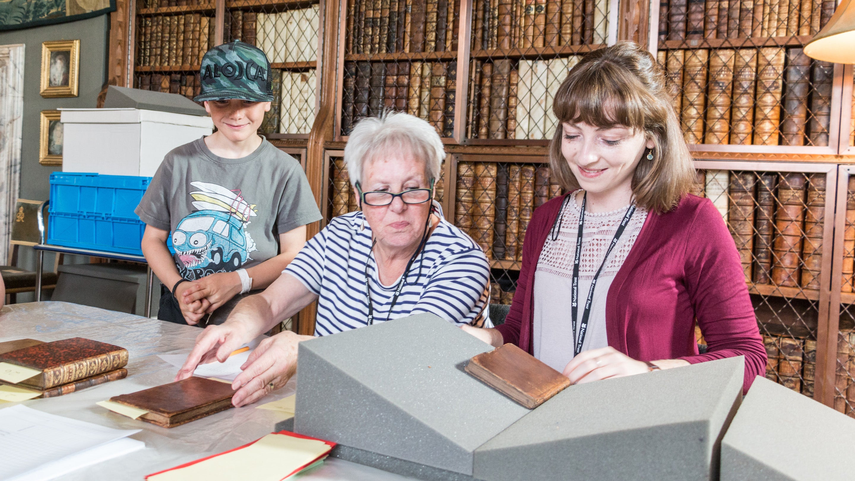 Conservation assistant working in the library at Blickling, with visitors