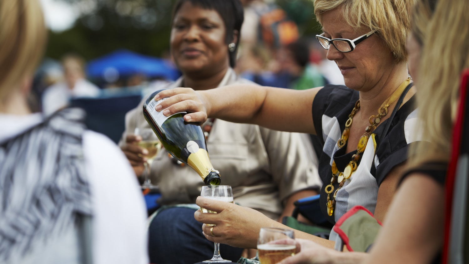 Group of women sitting and drinking champagne in the garden at Blickling Hall