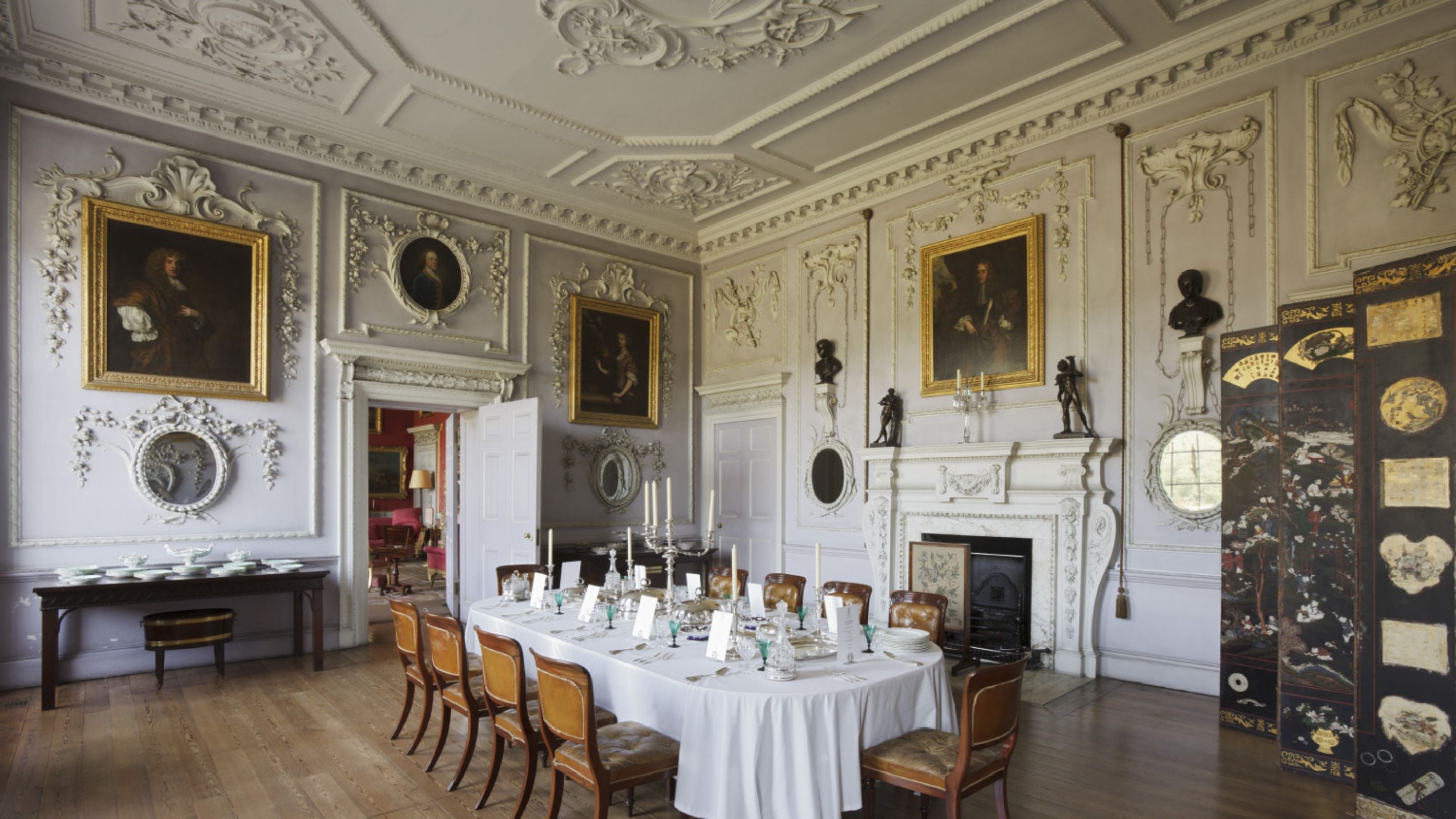 The pale purple Dining Room at Felbrigg Hall, Norfolk, with intricate plasterwork decorating the walls and ceiling.