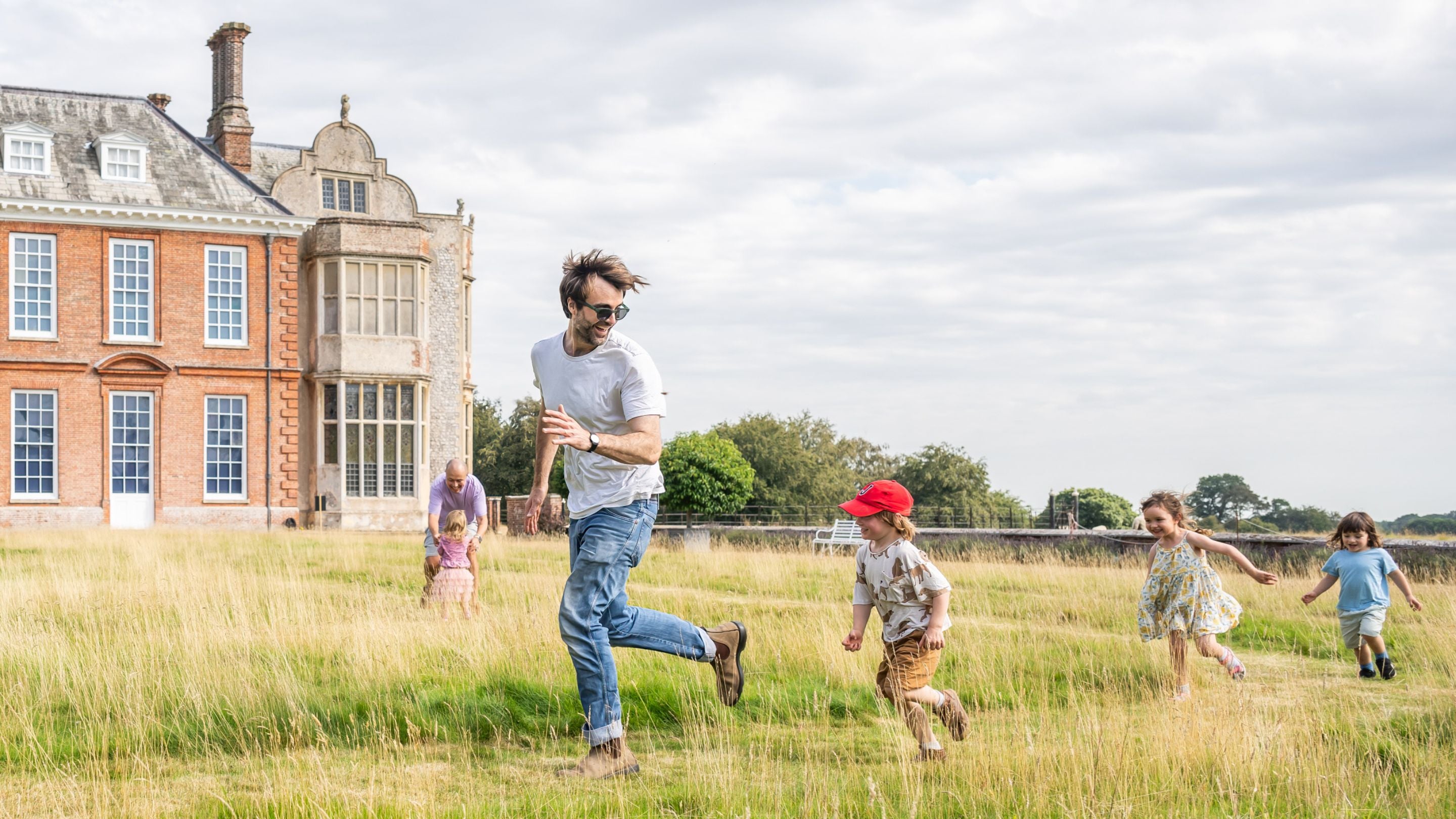 A family playing on the West Garden lawn in summer at Felbrigg
