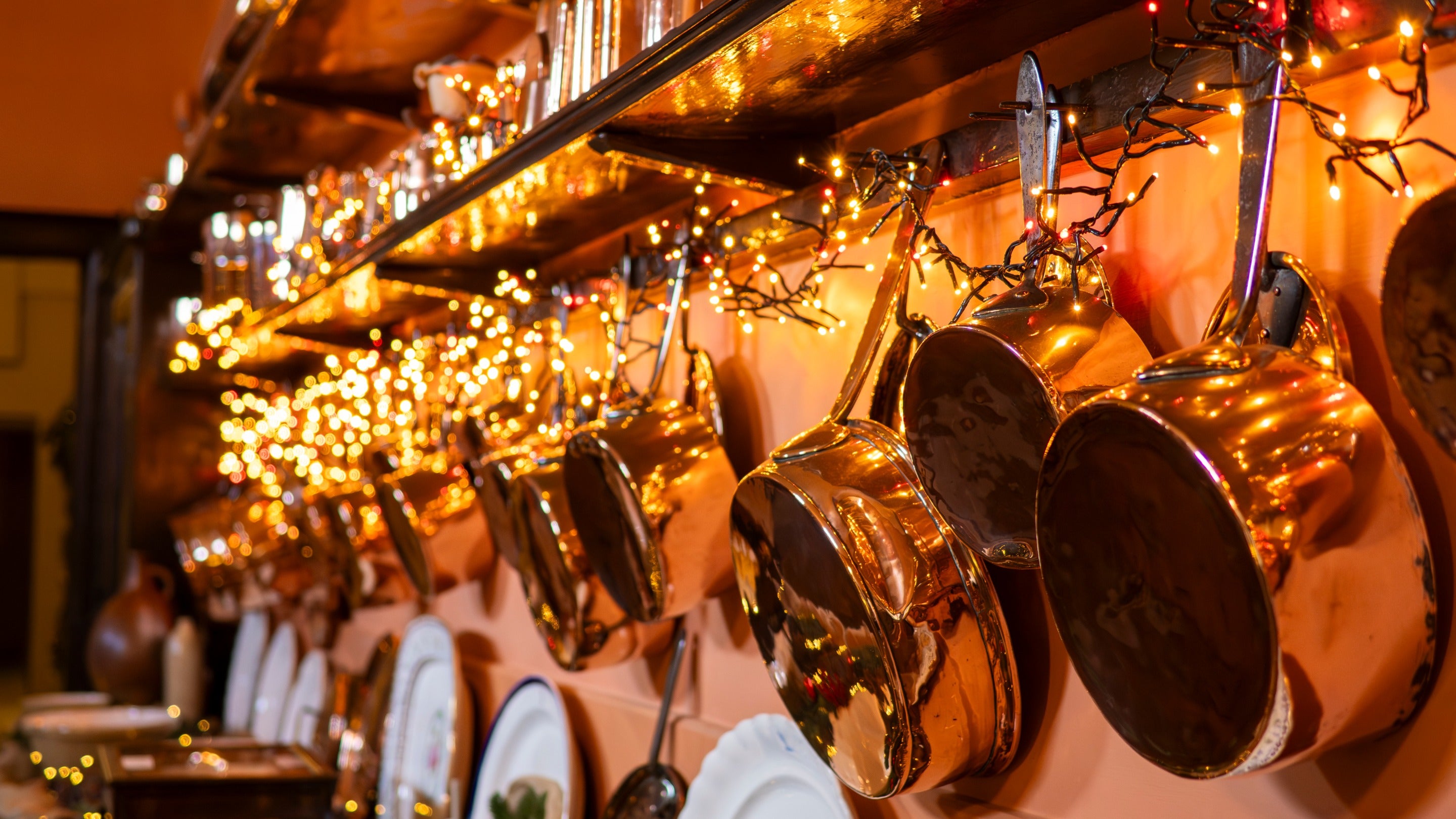 Copper pans and festive fairy lights in Felbrigg Hall's kitchen at Christmas.