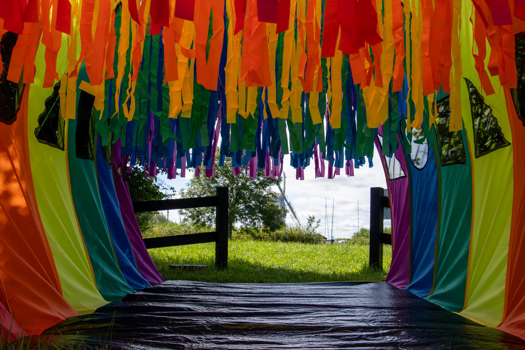 A colourful play tunnel with Horsey Windpump visible in the distance..