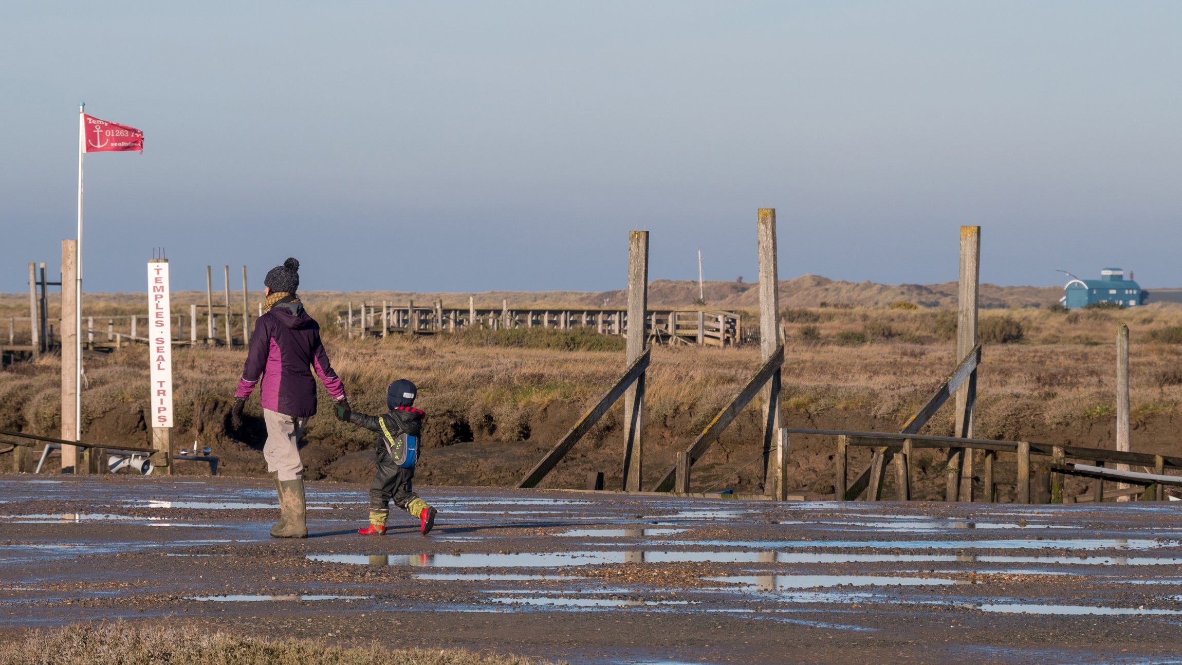 Family visiting Morston Quay dressed for Winter