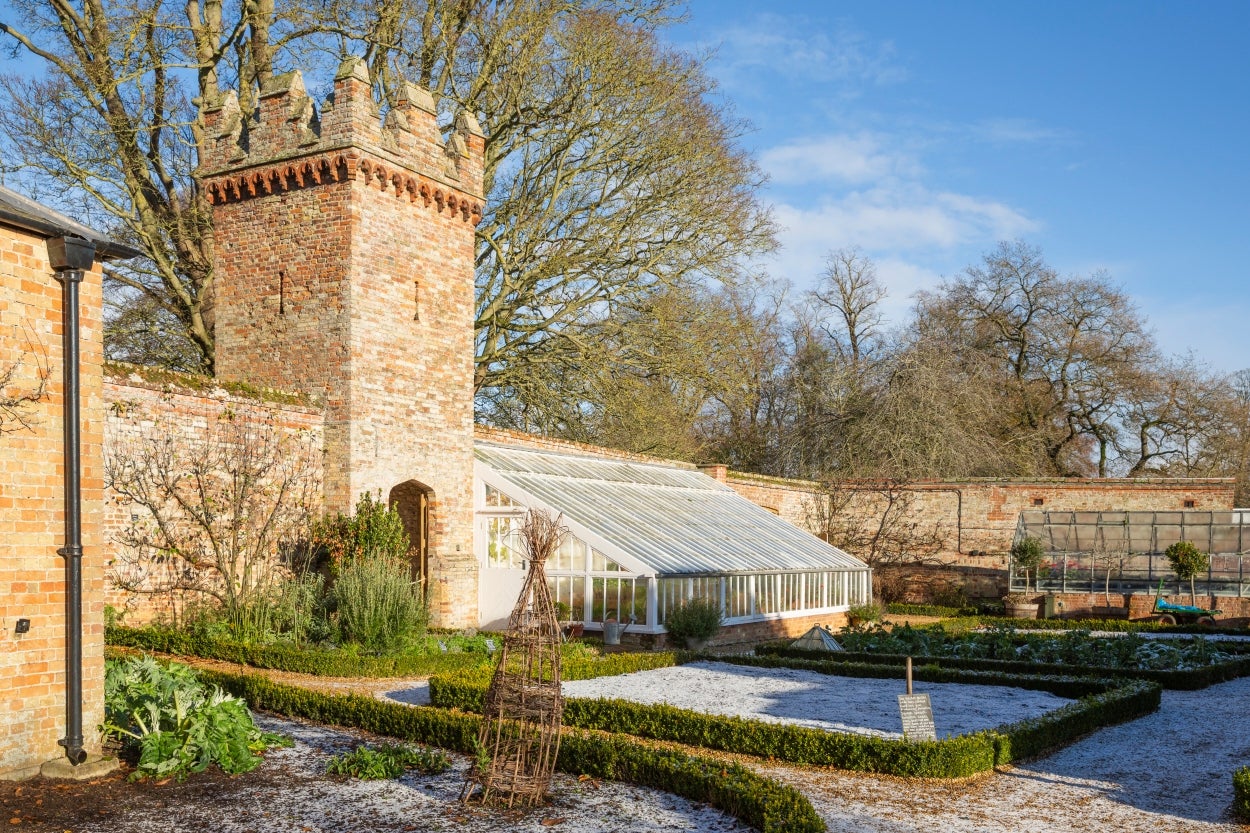 An image showing frost on the ground in he kitchen garden and the vegetable beds emptied out ready for spring.