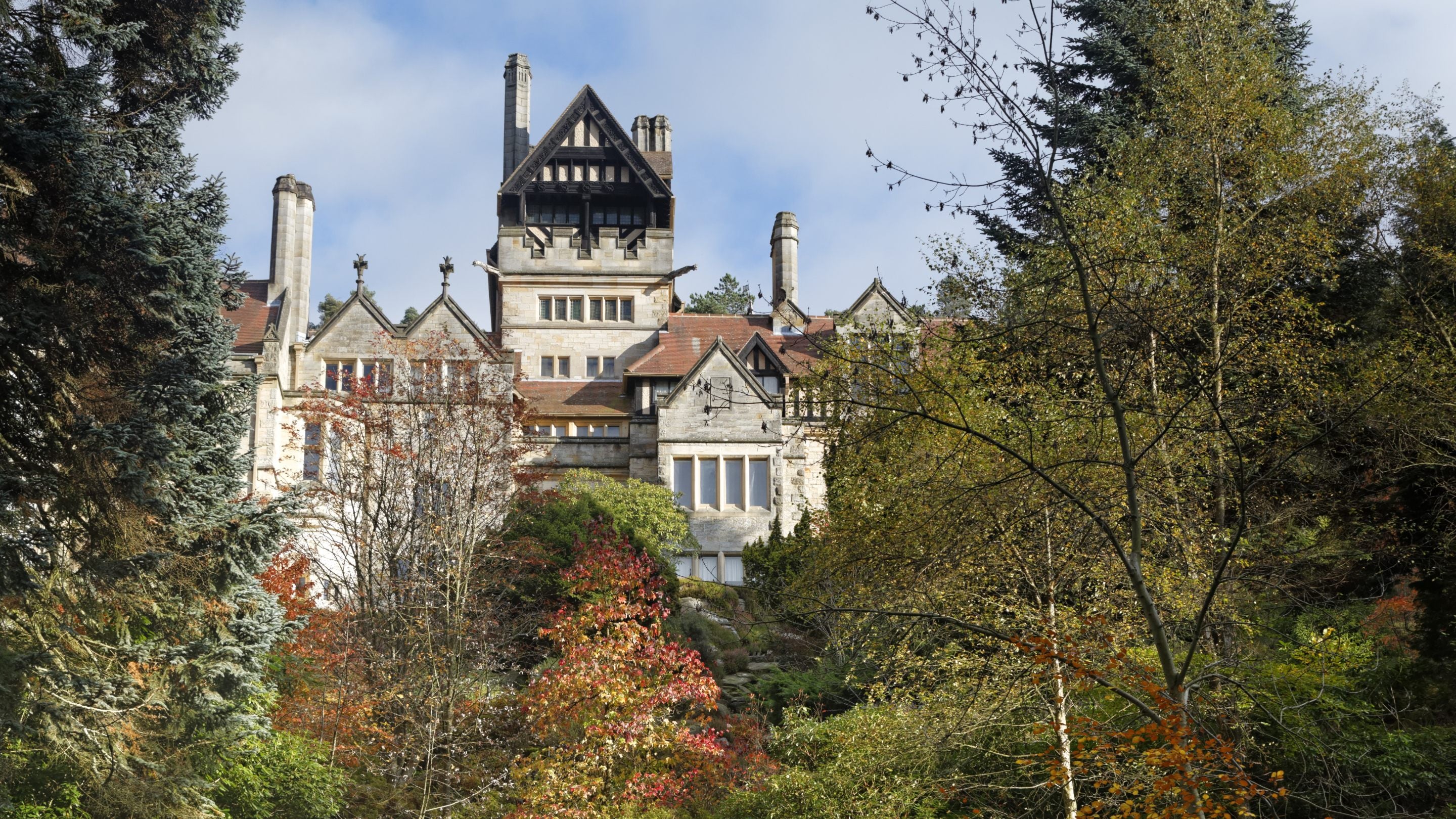 A gothic looking house surrounded by autumn trees