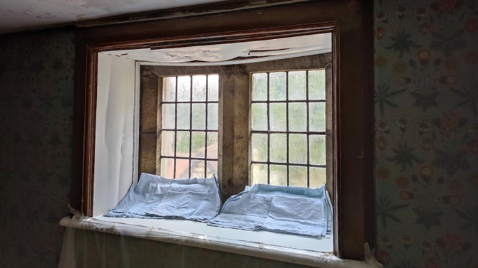 Water ingress around a window has damaged the ceiling causing paintwork to sag