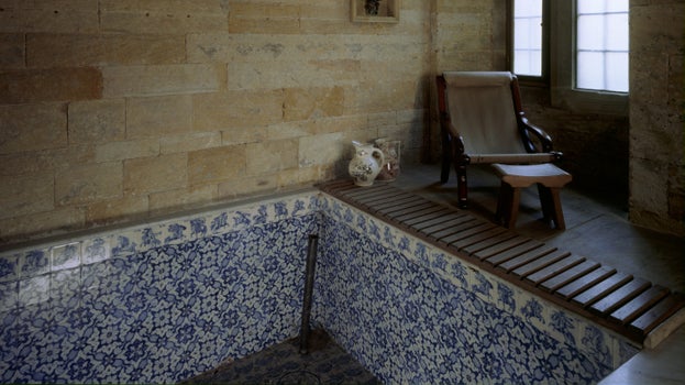The deep plunge bath with blue Delft tiles in the Turkish Bath Suite at Cragside House