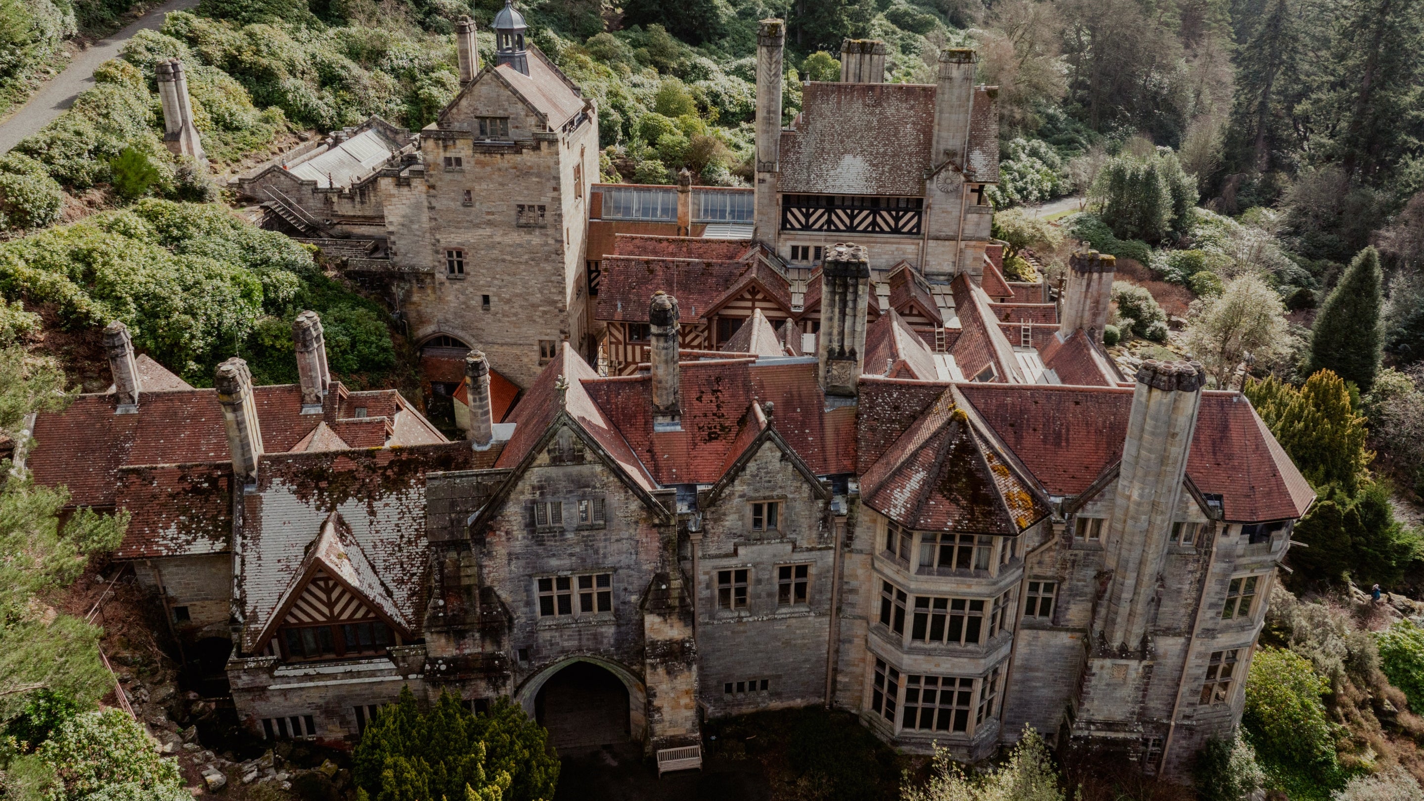 A drone view of Cragside's intricate roofscape featuring different levels, multiple roof slopes and adjoining ridges.