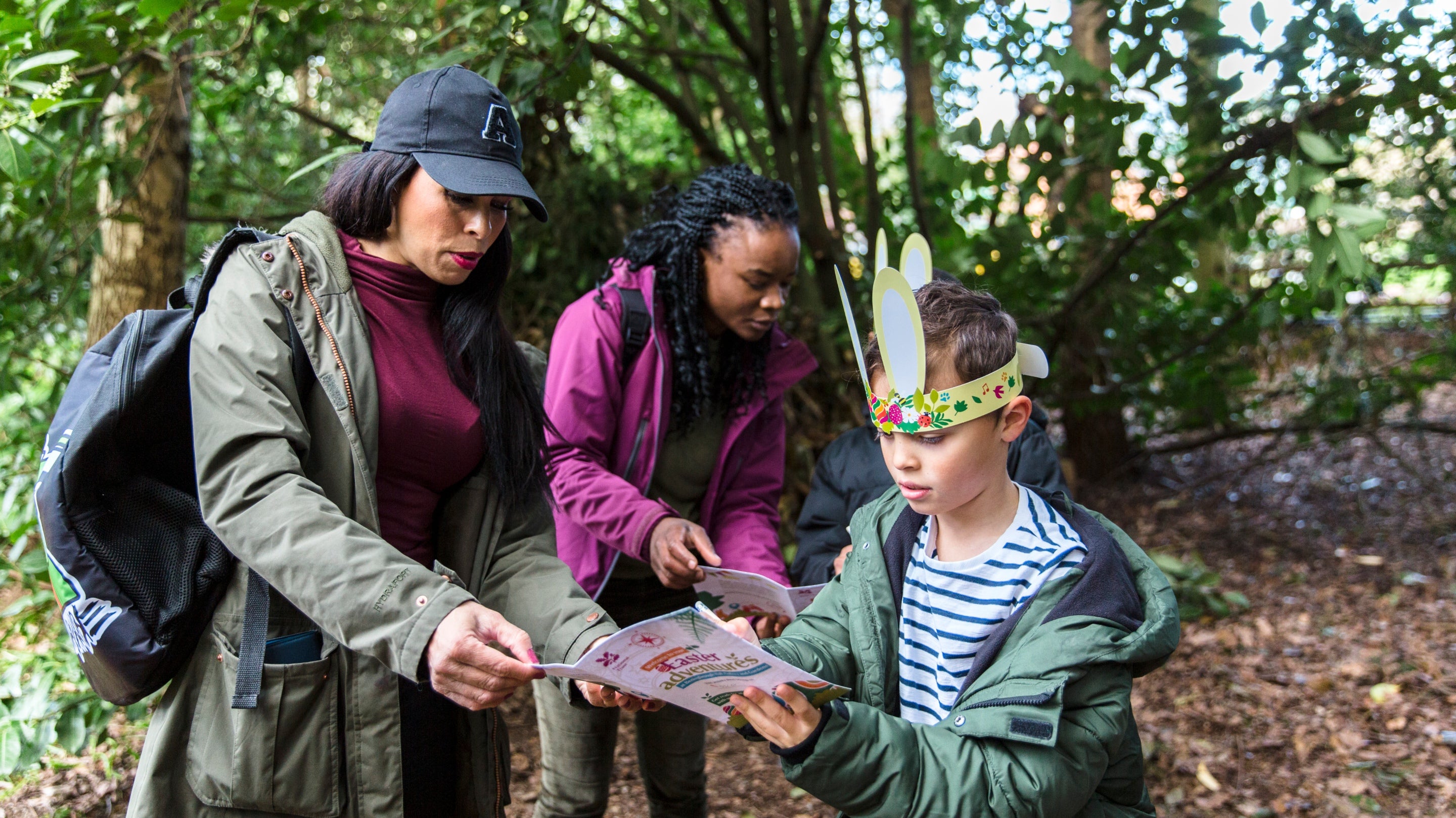 A family studying the activity sheet and map on an Easter Trail.