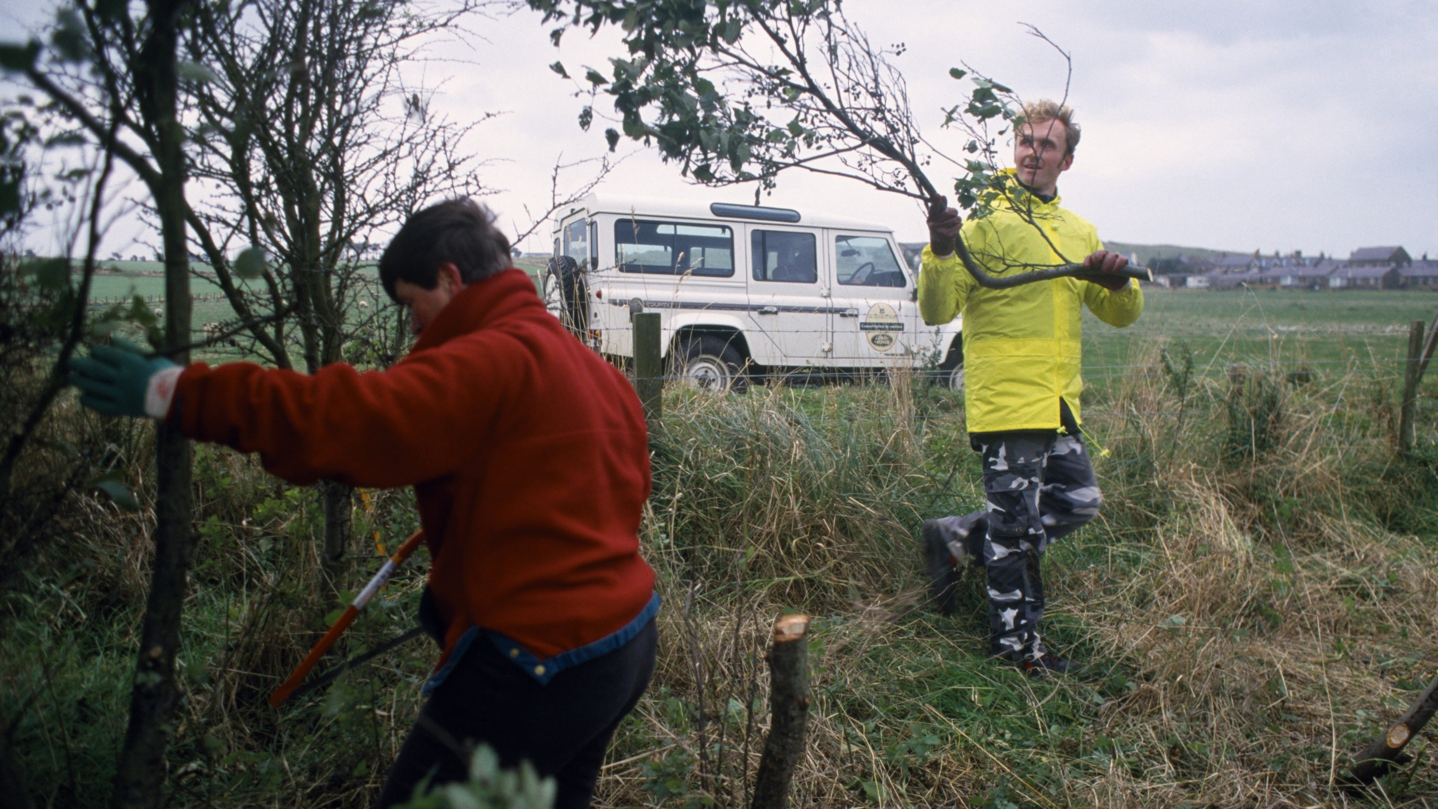 Two volunteers cutting branches at Newton Pool Nature Reserve, Embleton and Newton Links, Northumberland