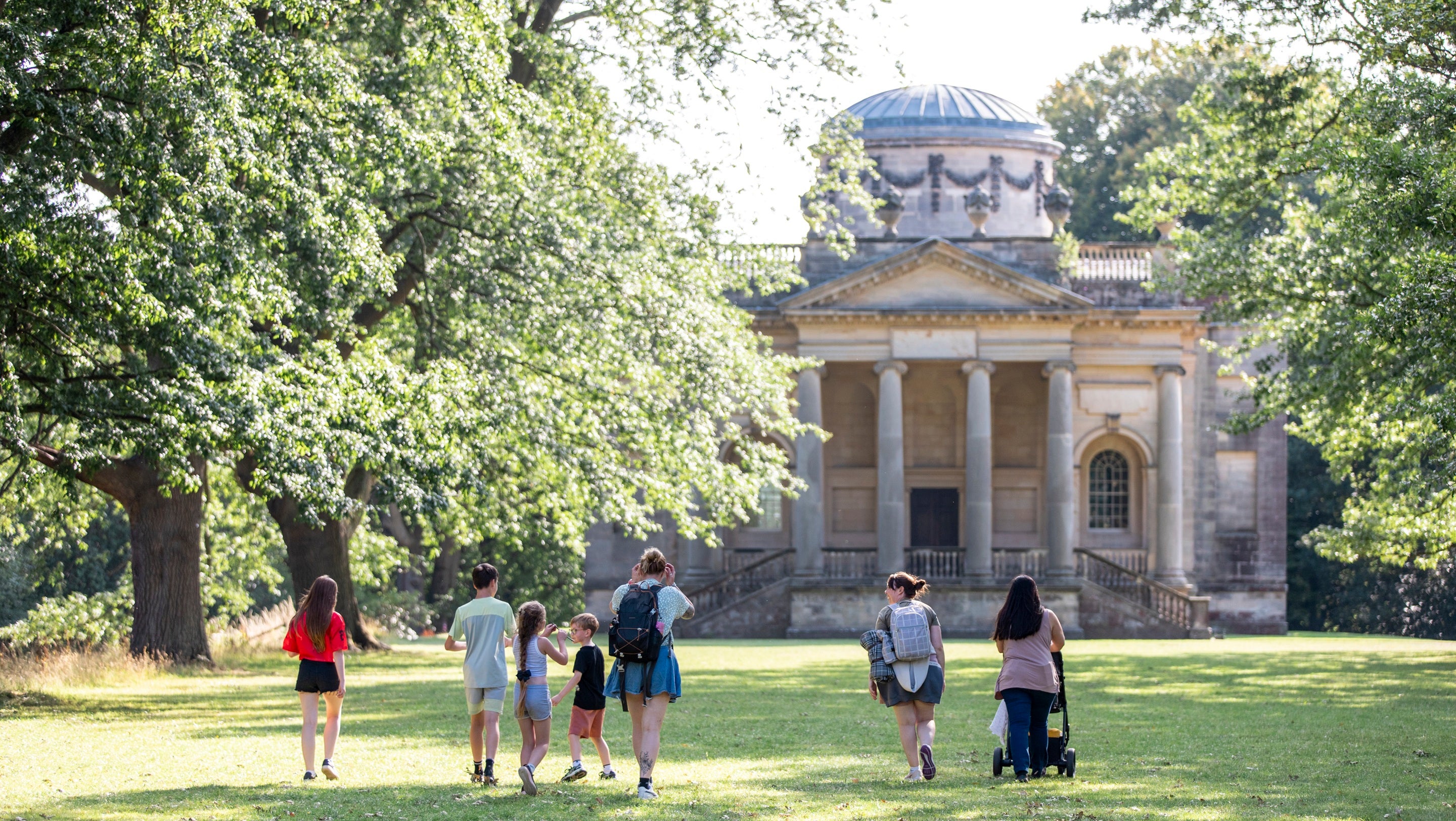 Visitors walking along the tree-lined avenue with Gibside chapel ahead