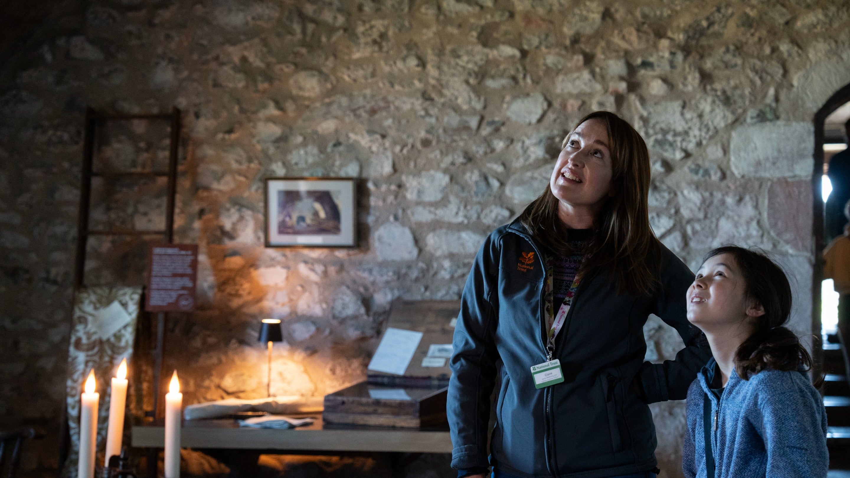 Visitor and volunteer in the Ship Room at Lindisfarne, Northumberland