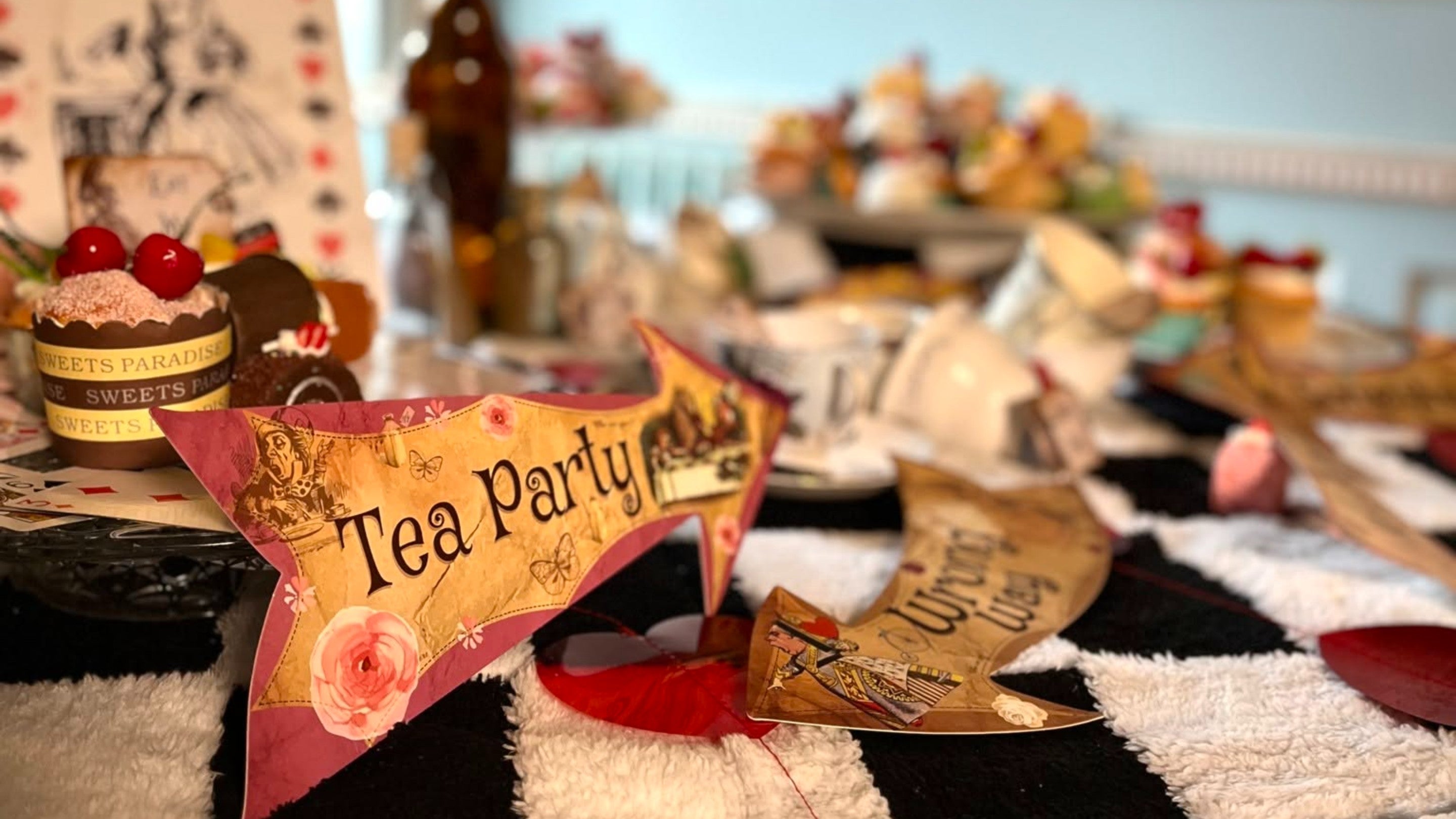 Display table with Tea Party sign and Alice in Wonderland inspired decorations