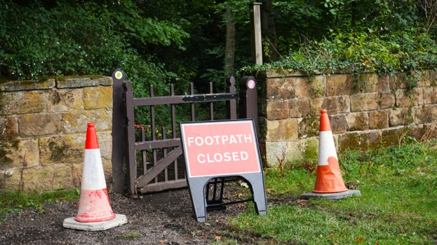 Path closed sign with cones in front of gate accessing the multi-user trail