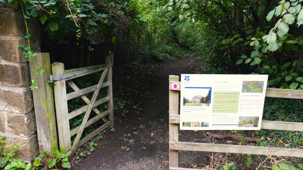 An open gate on the existing path on Ormesby estate with a large sign explaining the planned work