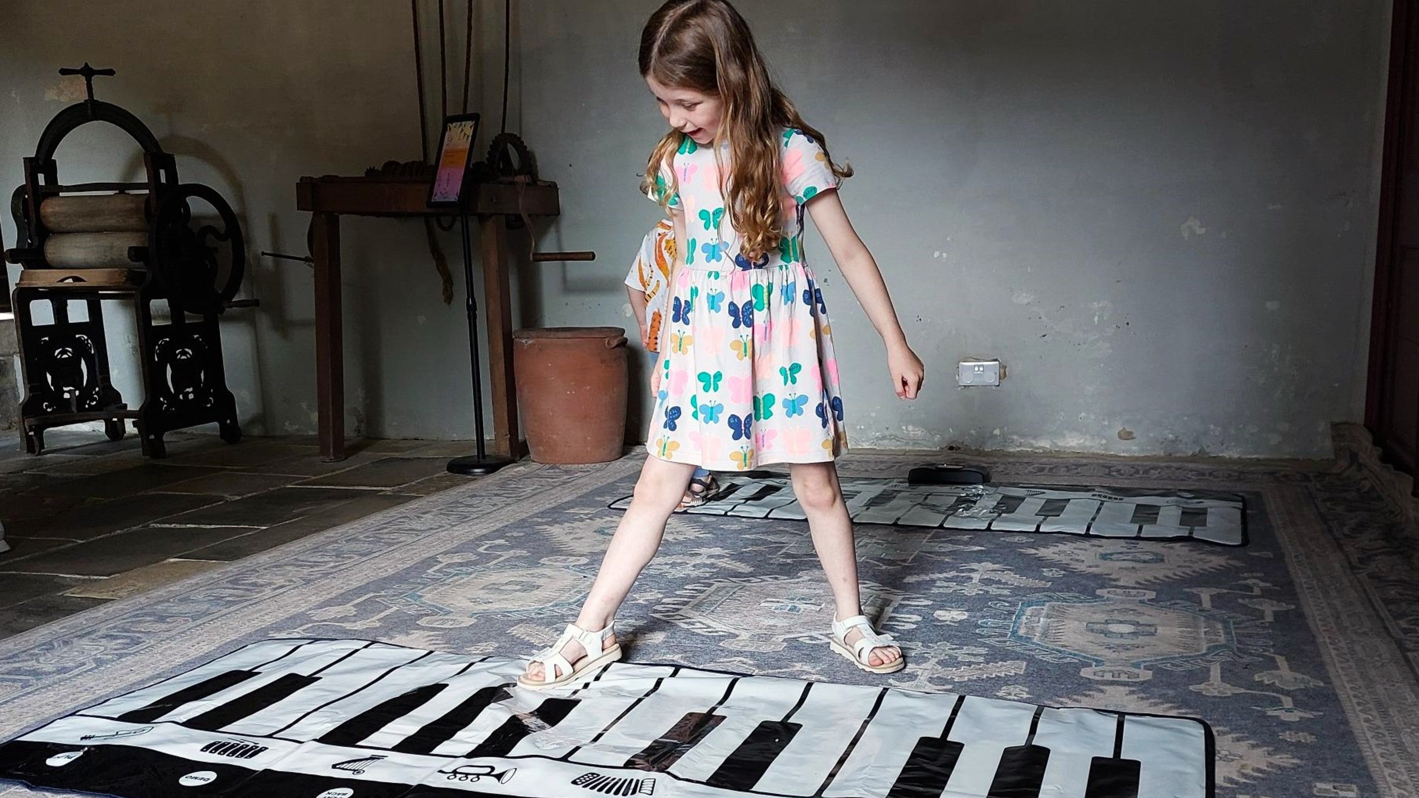 Girl playing the floor piano in the old laundry room at Ormesby Hall