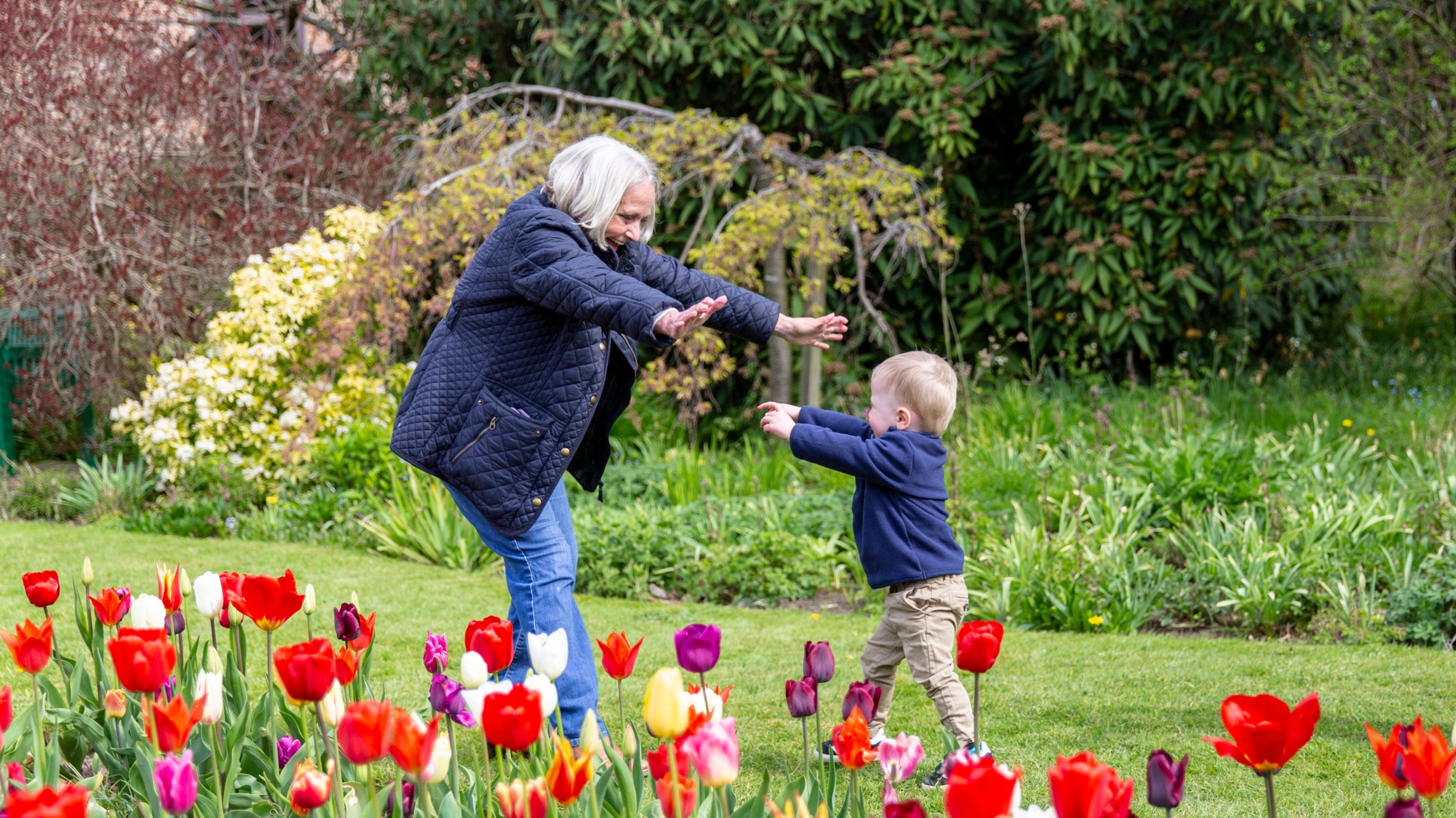 A grandmother and grandchild play together in the gardens, Ormesby Hall, North Yorkshire