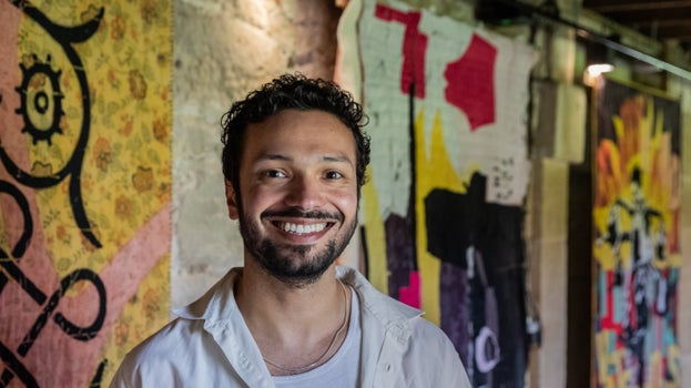 Artist Jacob Goff stands in front of his winning piece, Many Hands, a triptych of hand made quilts, in Seaton Delaval Hall's Kitchen Passage